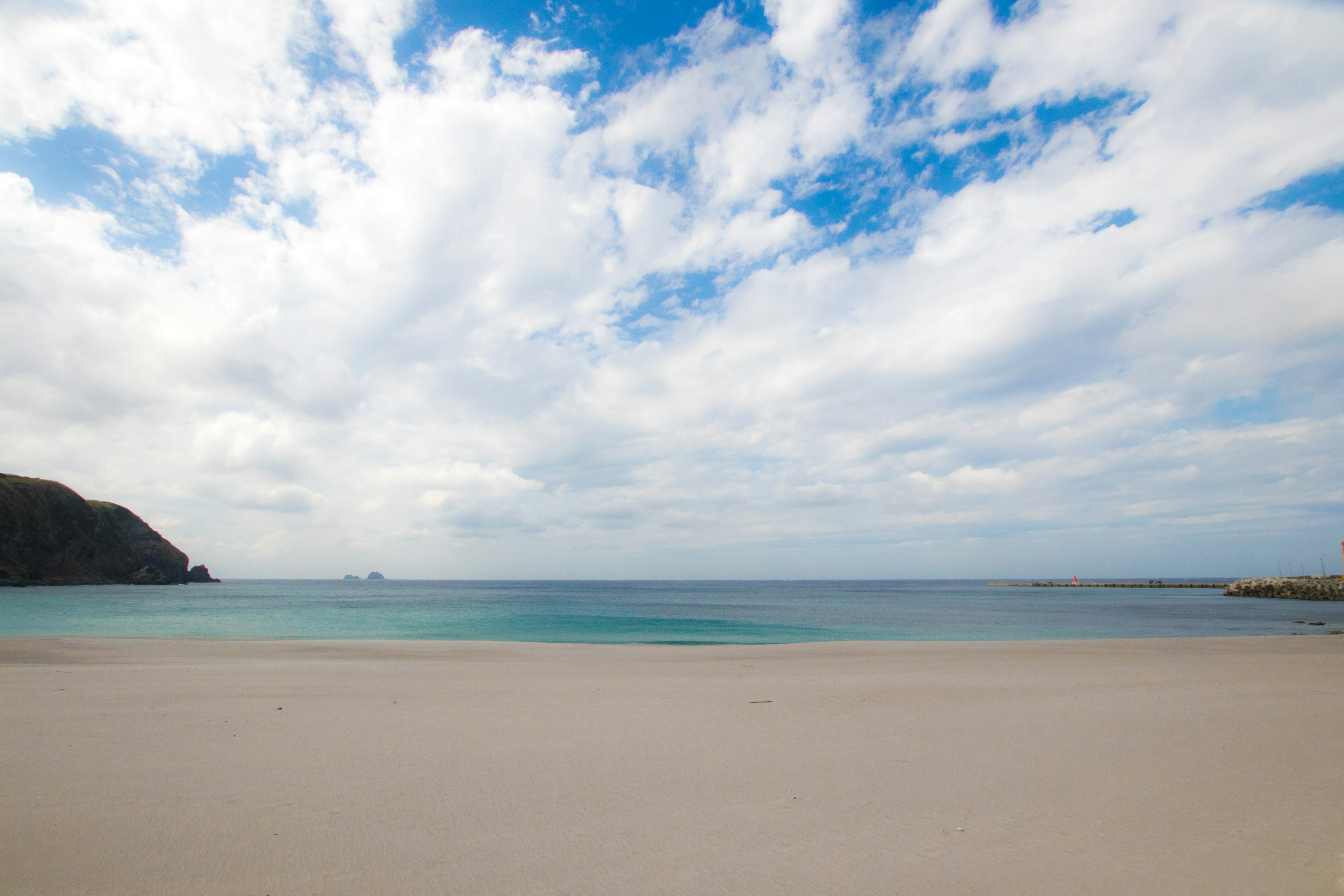 Vista panoramica di una spiaggia con cielo blu e sabbia bianca