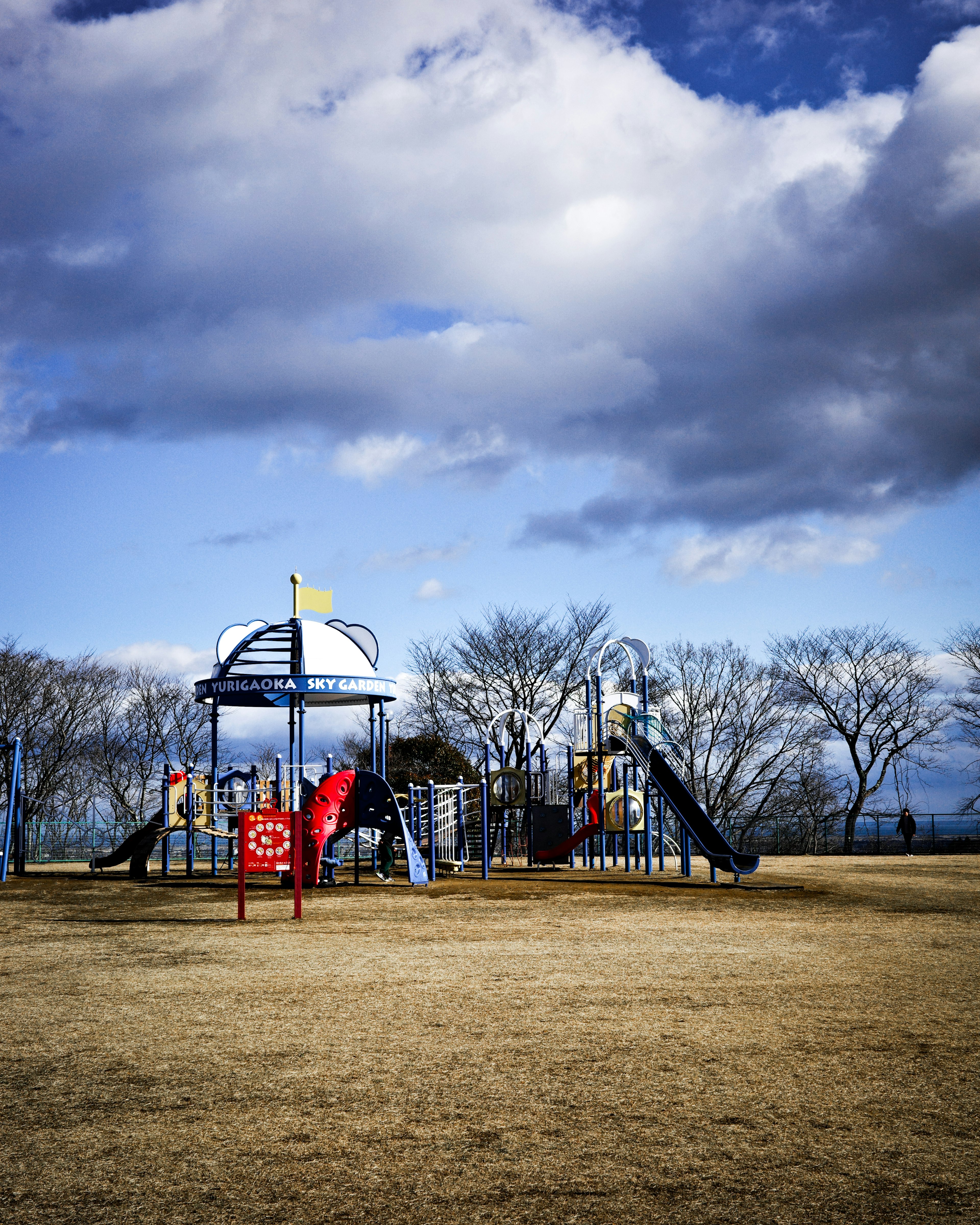 Parco giochi con scivoli e attrezzature sotto un cielo nuvoloso