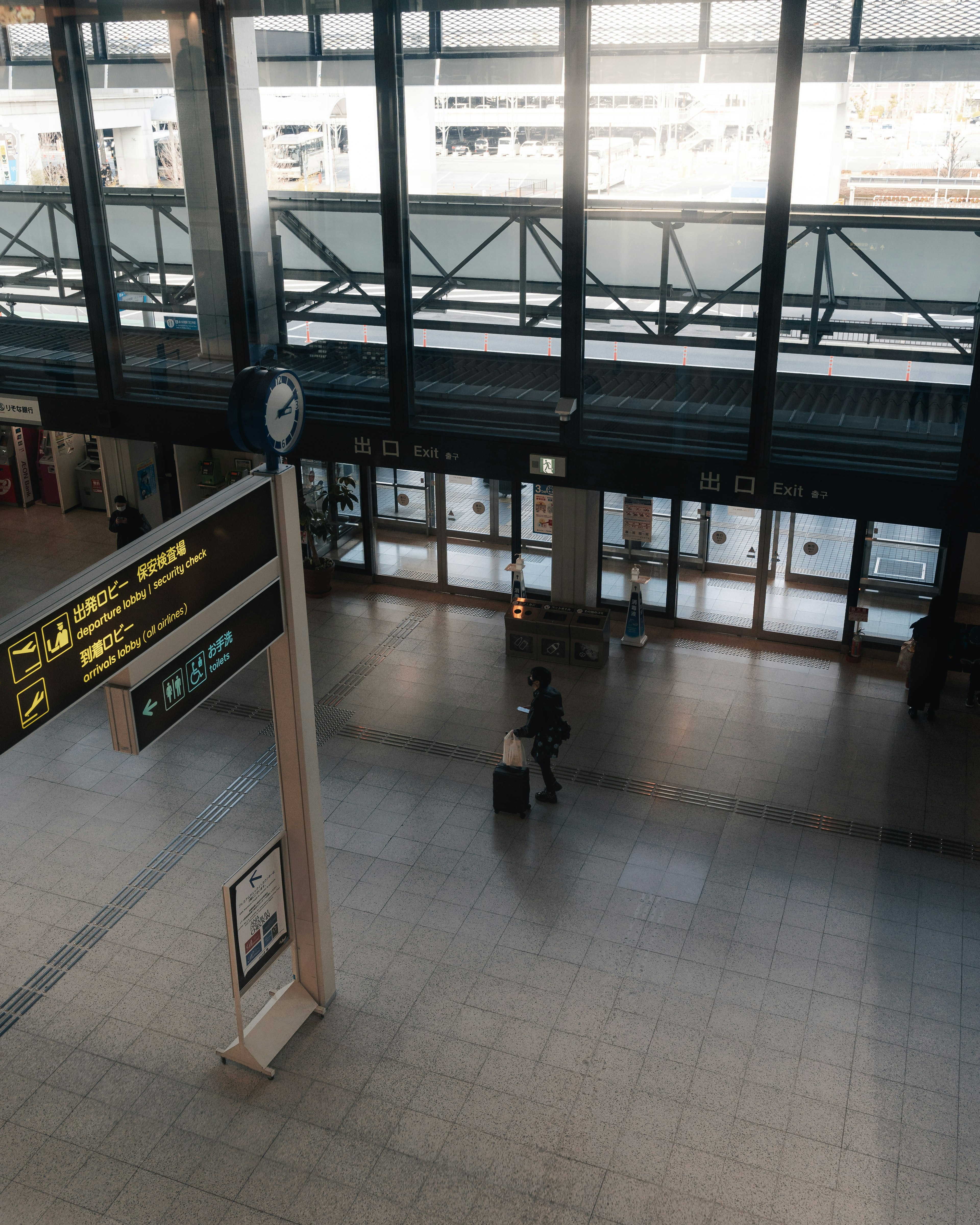 Interior luas stasiun kereta dengan cahaya yang masuk melalui jendela dan jam yang terlihat