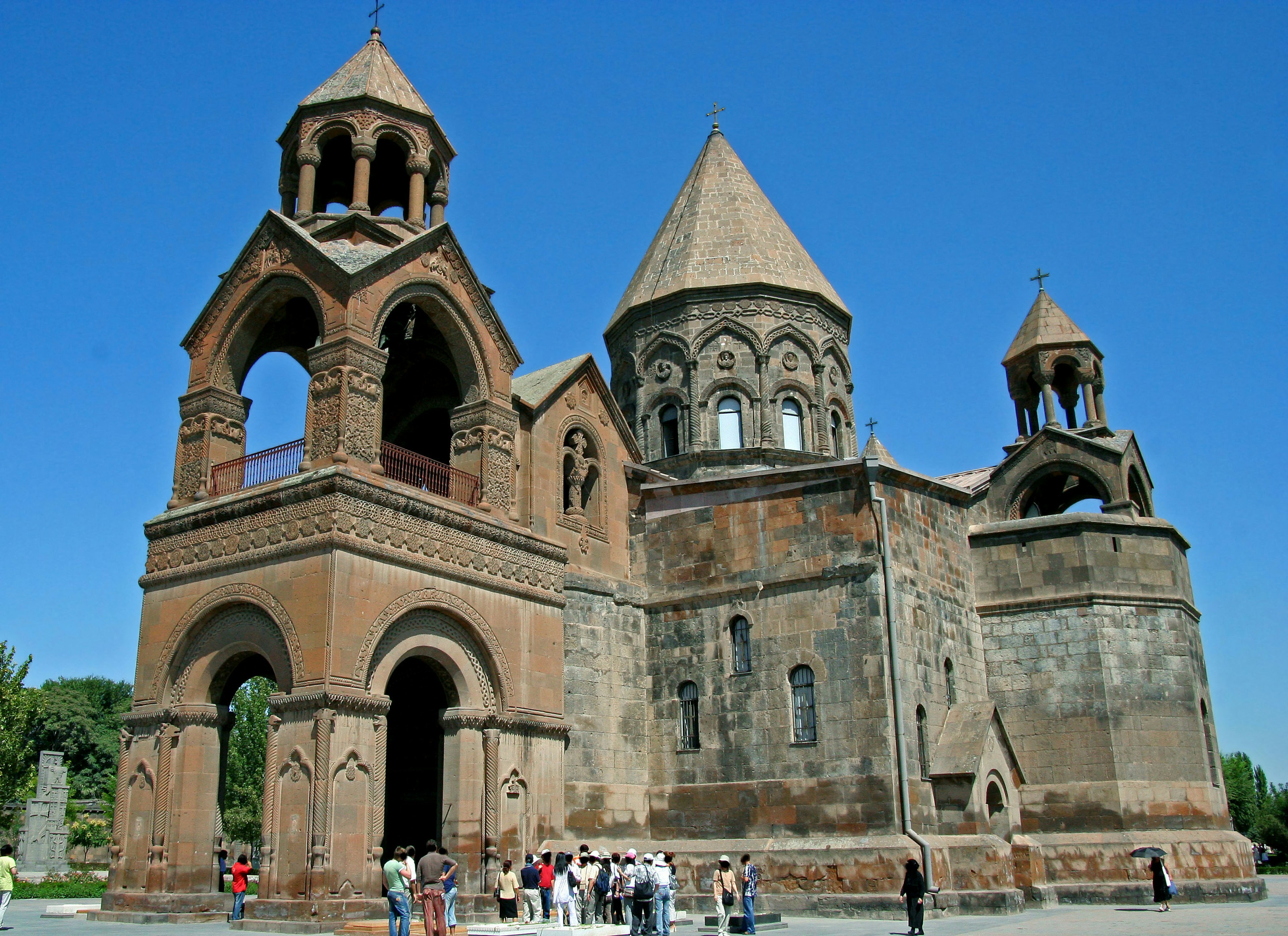 Hermosa fachada de iglesia armenia con torres distintivas y paredes de piedra rojiza