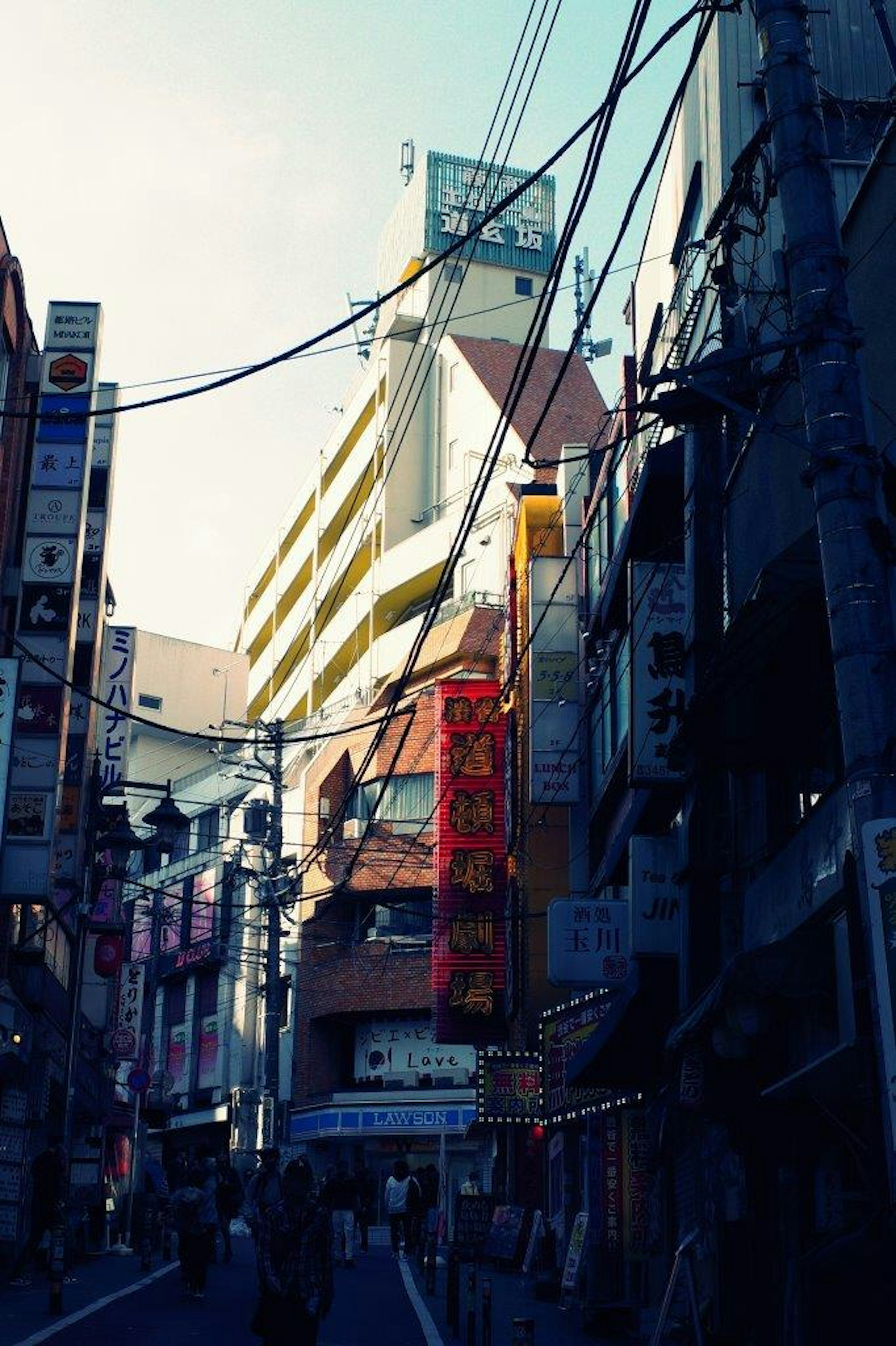 Busy urban street featuring tall buildings and neon signs