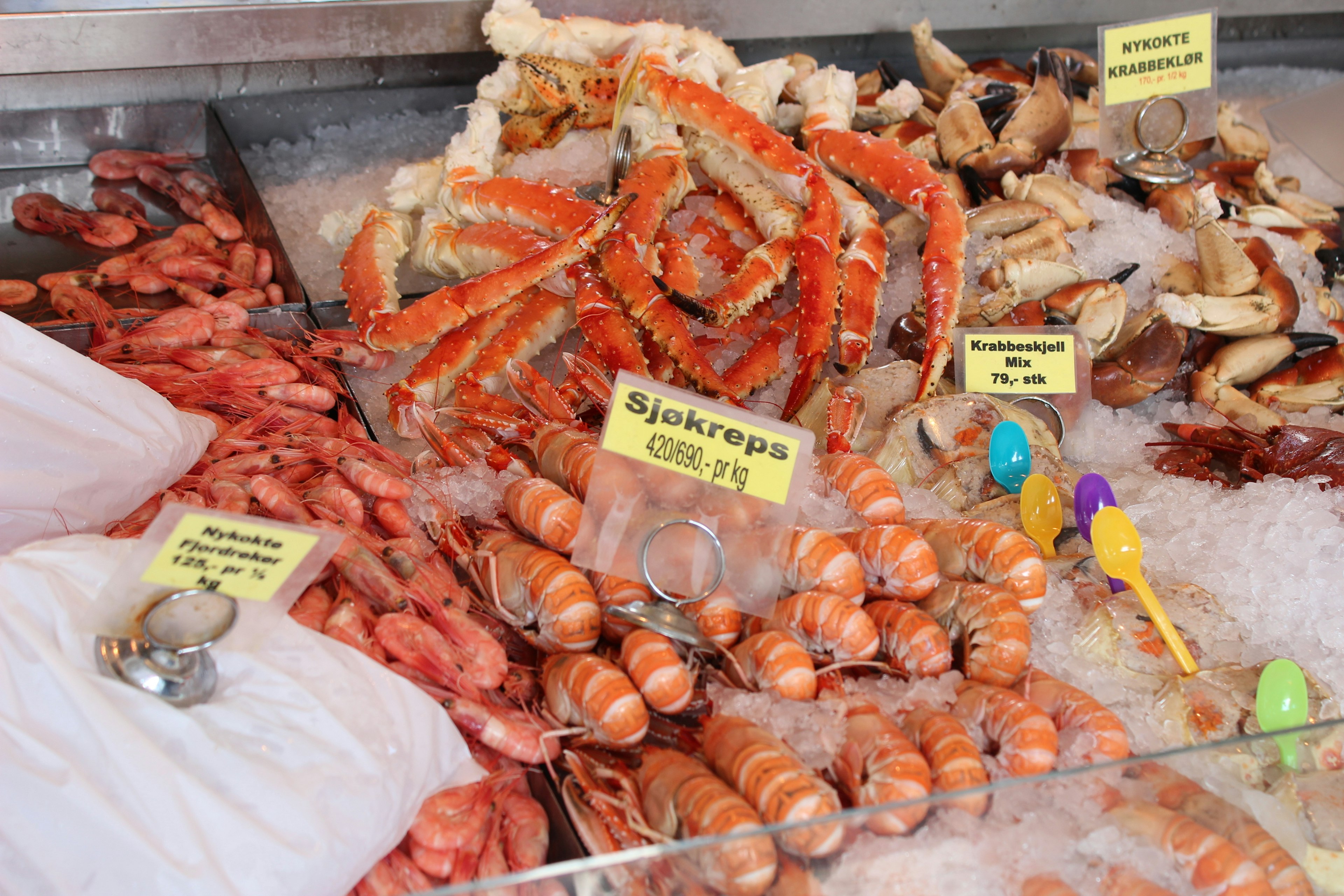 Mariscos frescos exhibidos en un mercado con cangrejos y camarones sobre hielo