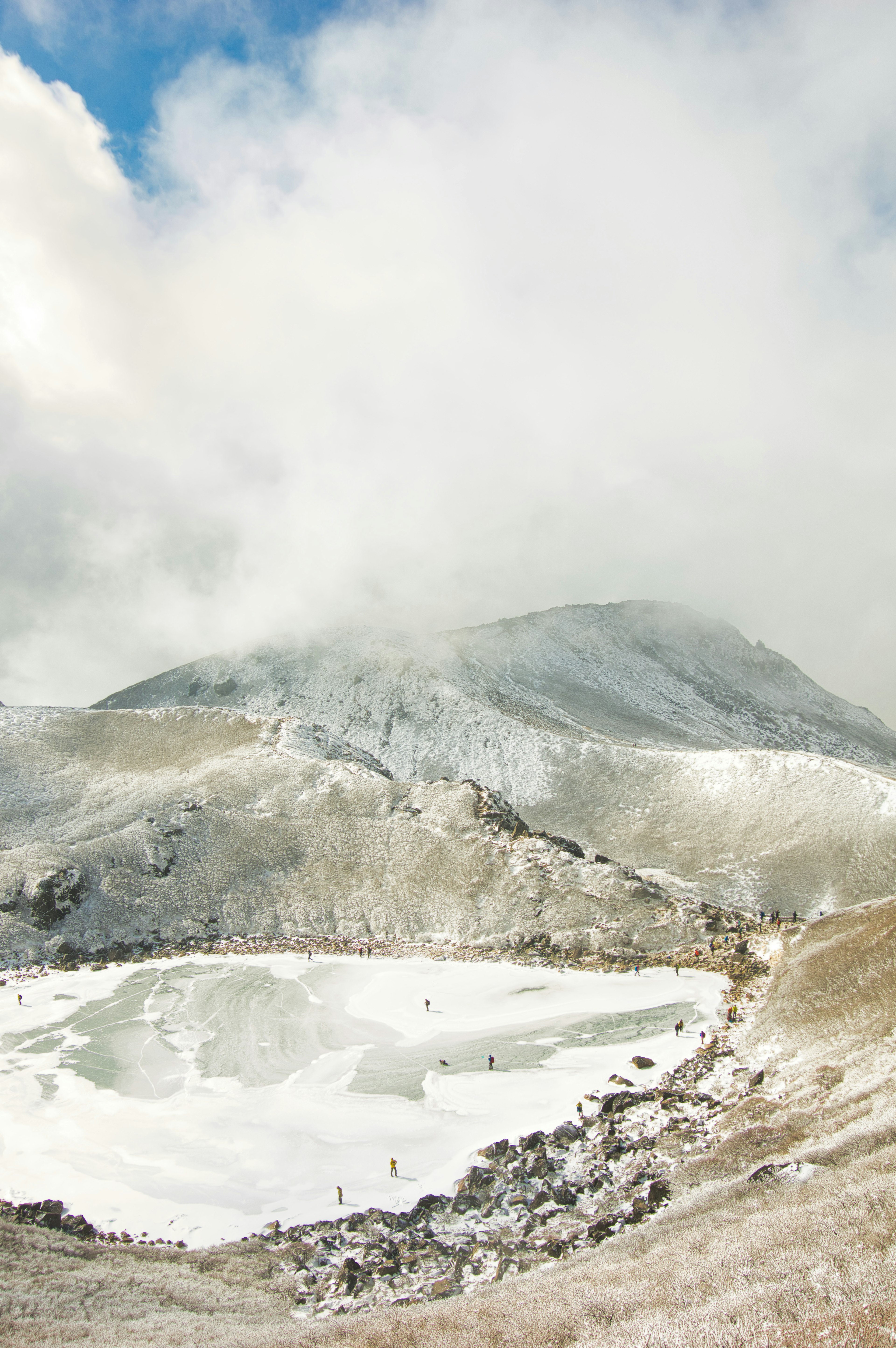 被雪覆蓋的山景與霧和冰凍湖泊