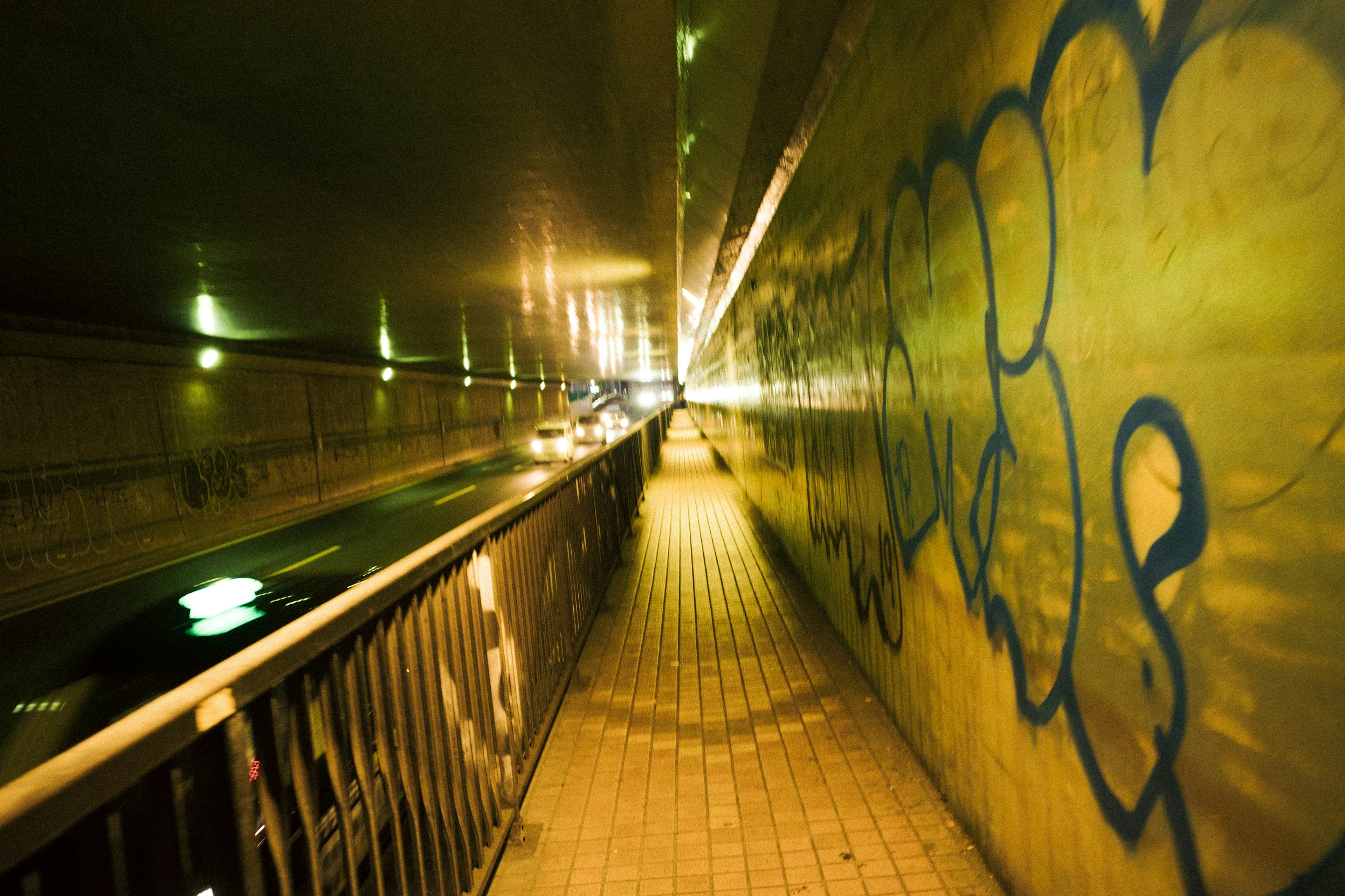 Dunkler Tunnelweg mit Graffiti und Beleuchtung