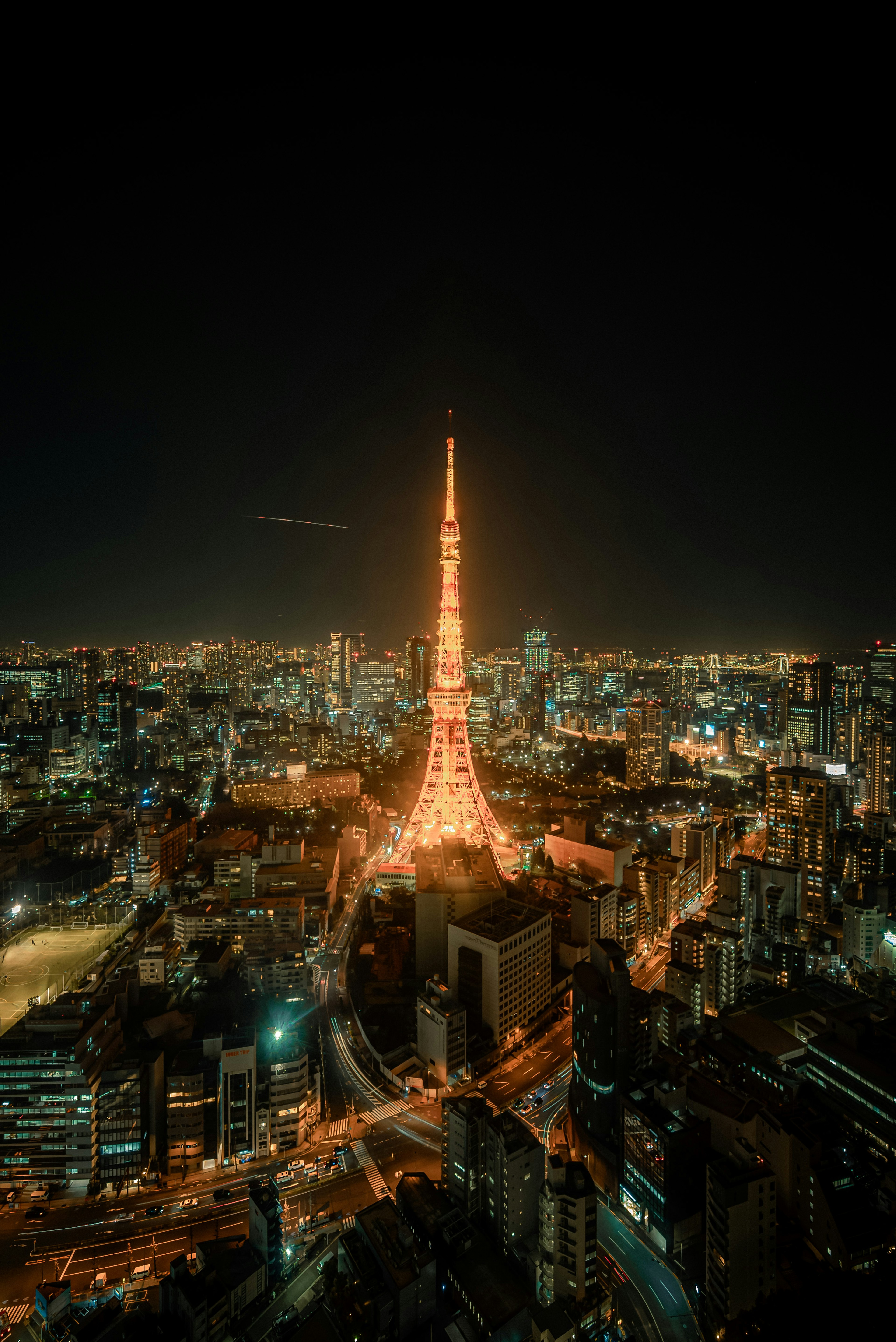 Panoramablick auf den beleuchteten Tokyo Tower bei Nacht mit der Skyline der Stadt