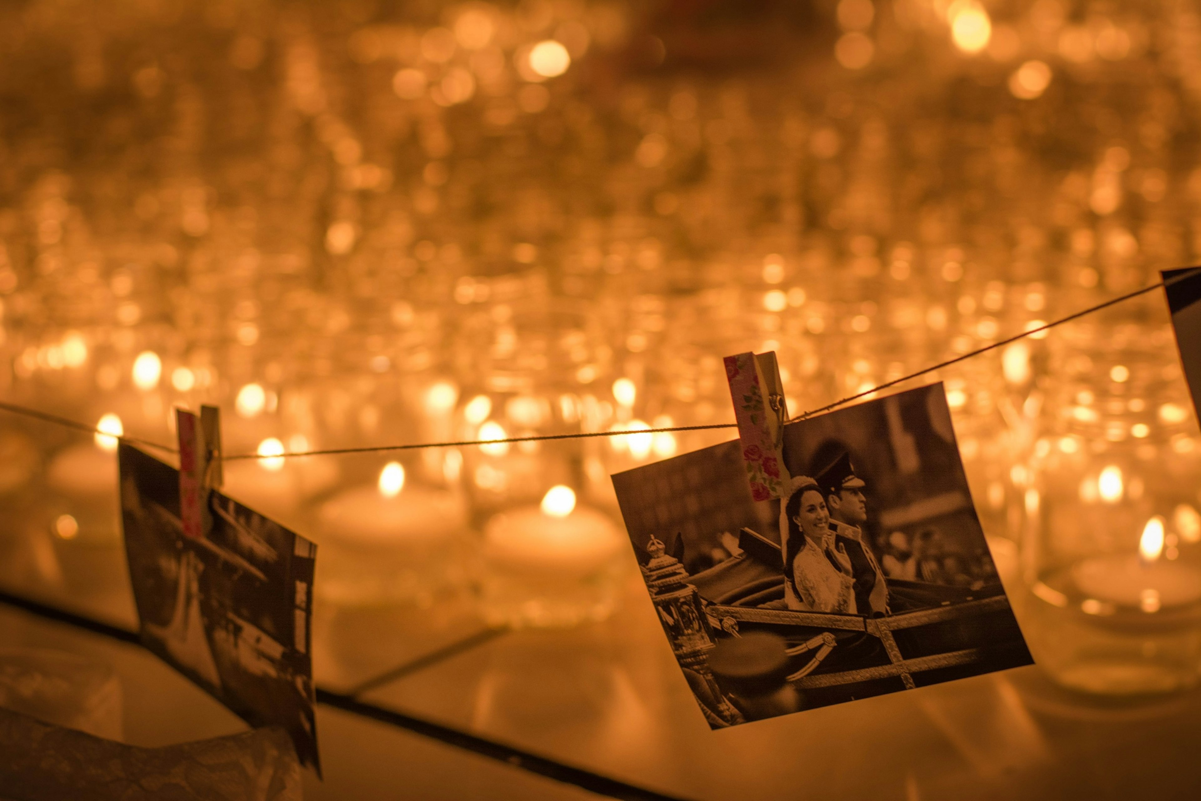 Una escena serena con fotos colgadas frente a velas naranjas