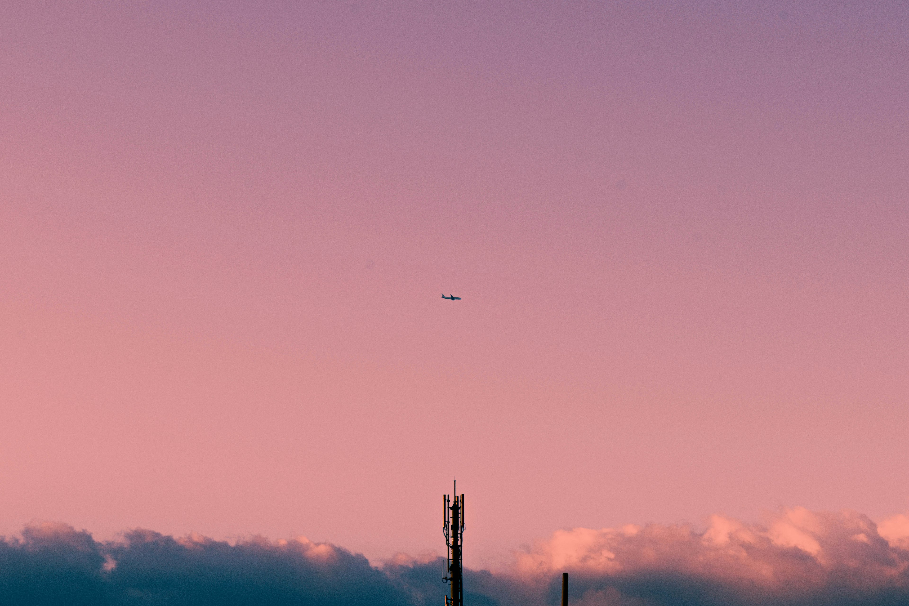 Avión en el cielo del atardecer con una torre de comunicación