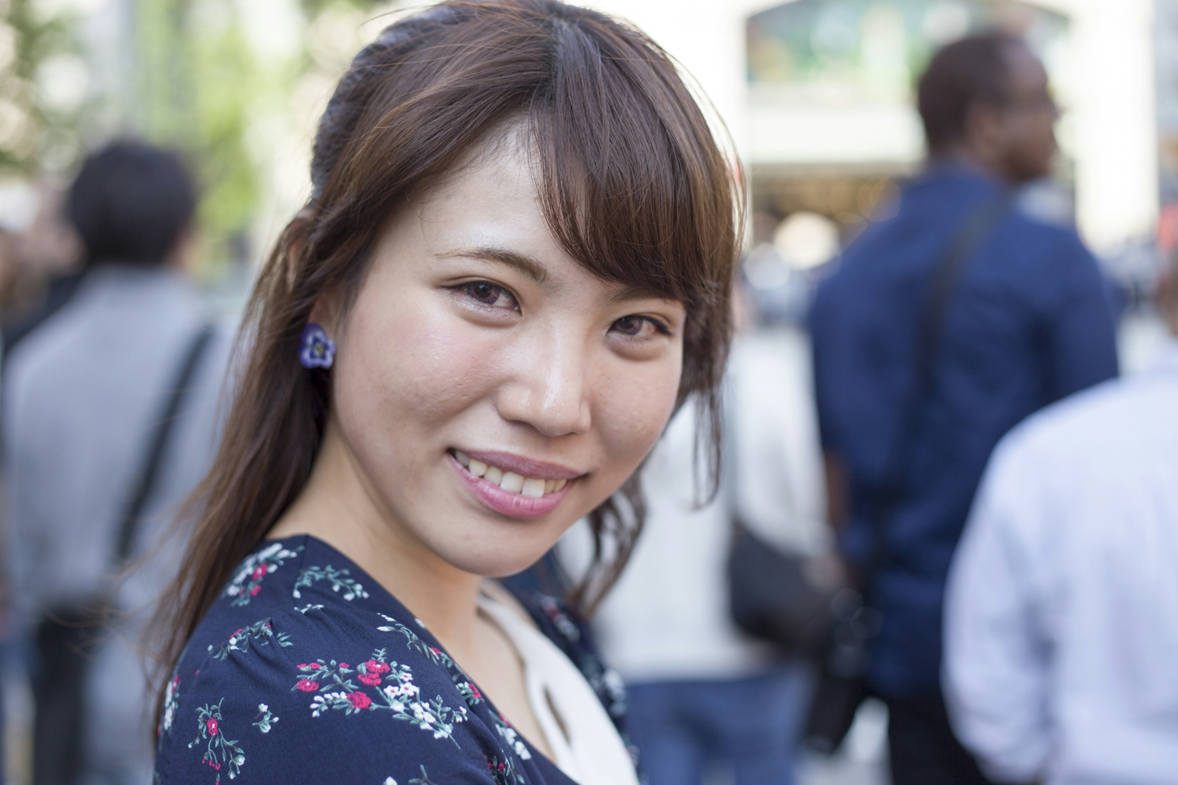 Retrato de una mujer sonriente en un parque con ropa floral