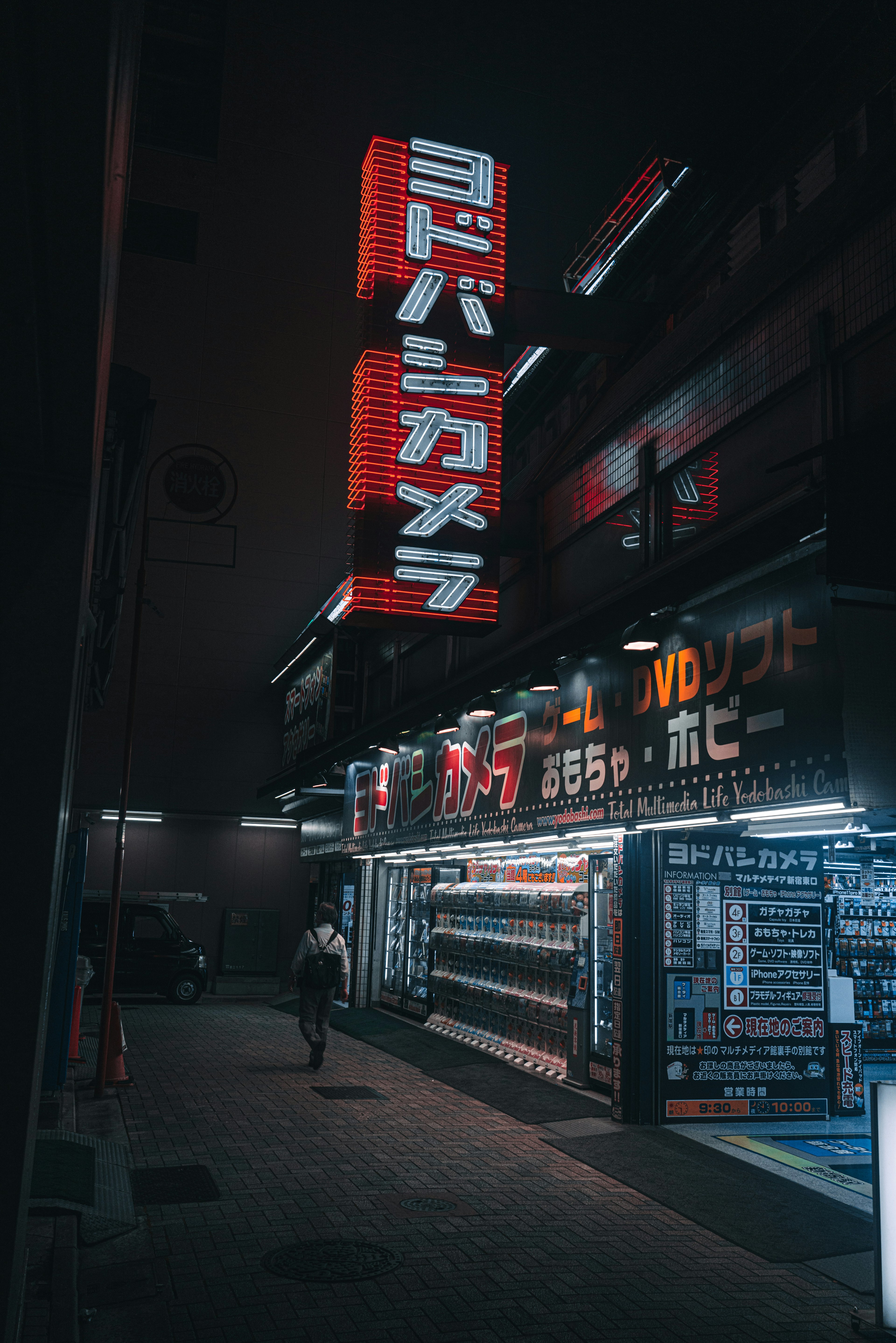 ป้ายและร้านค้า Yodobashi Camera ในตอนกลางคืนที่มุมถนน