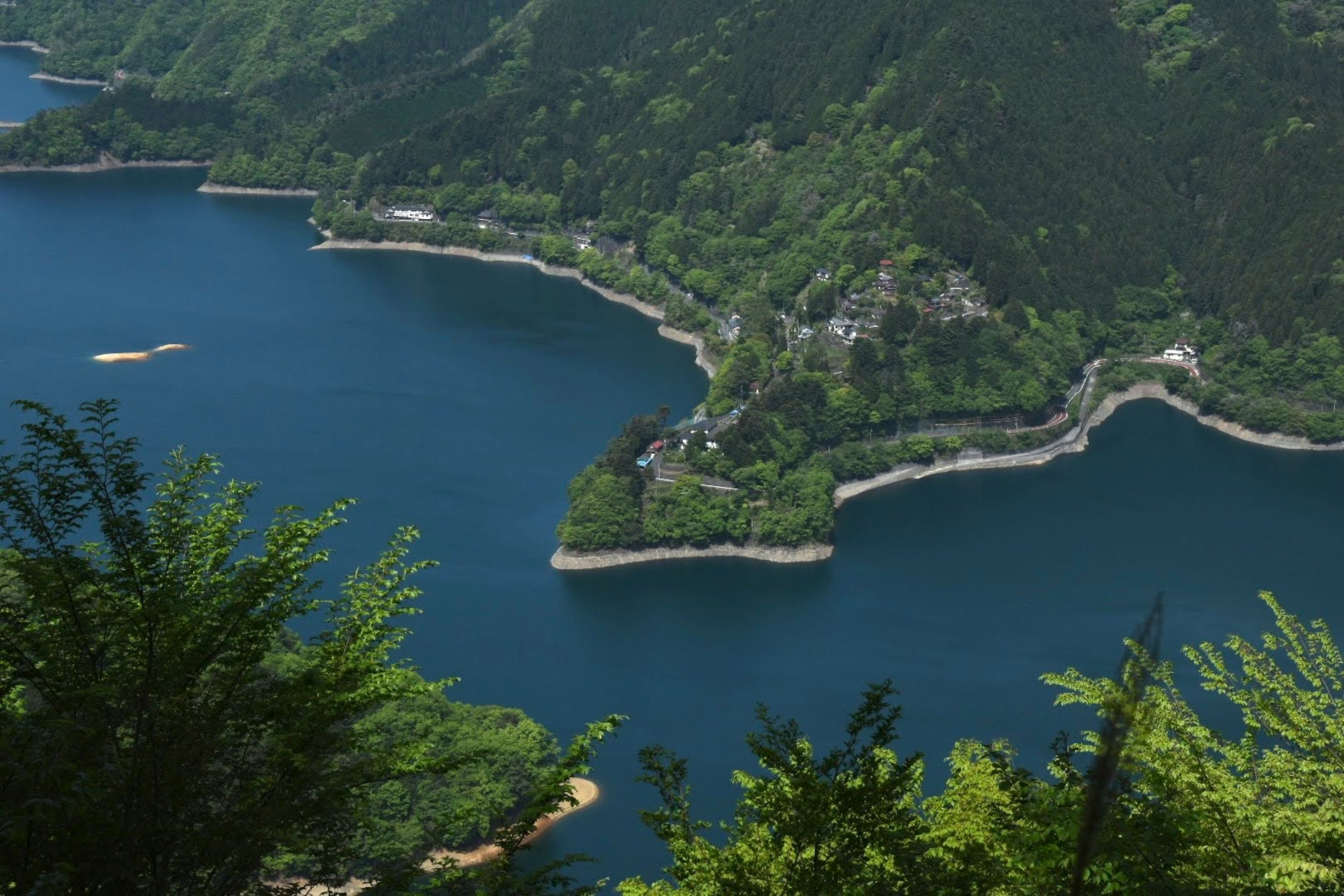 Vista panoramica di un lago circondato da montagne lussureggianti