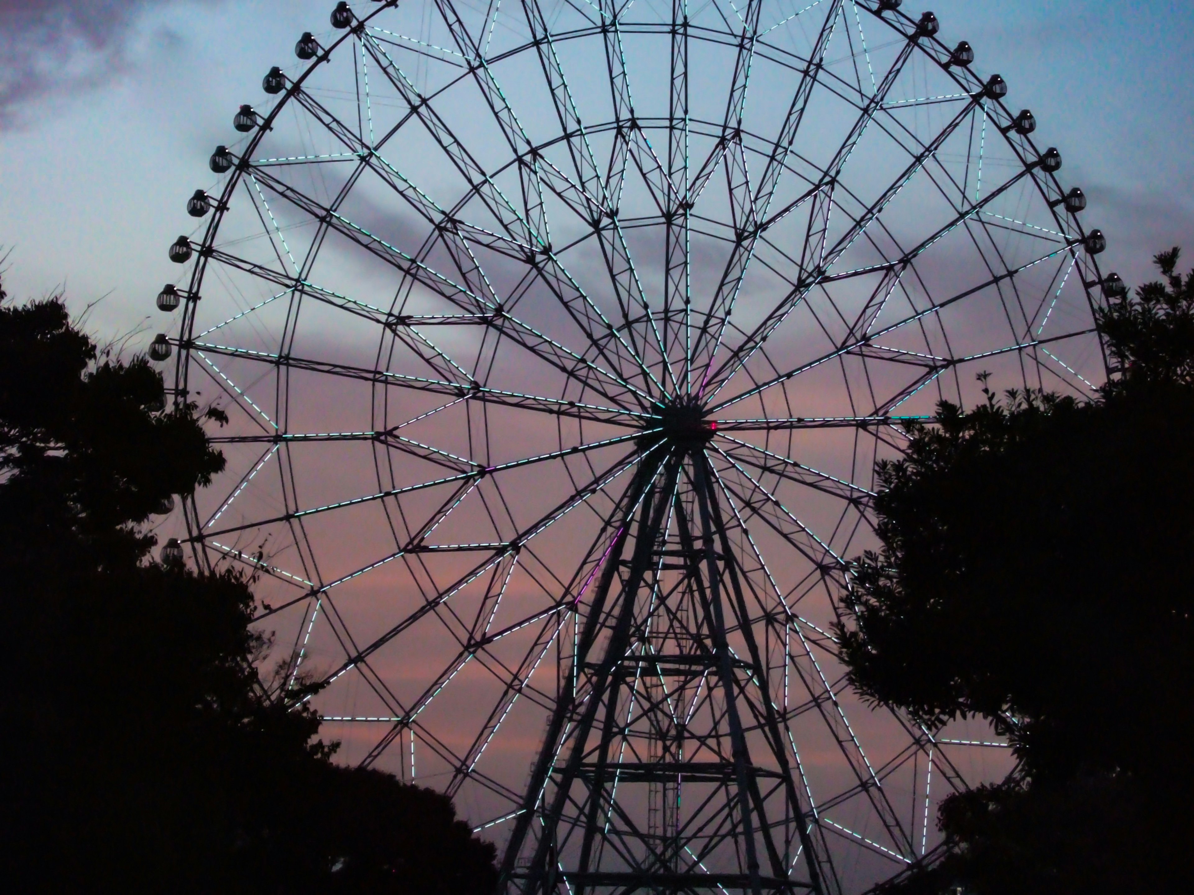 Silhouette of a Ferris wheel against a sunset sky