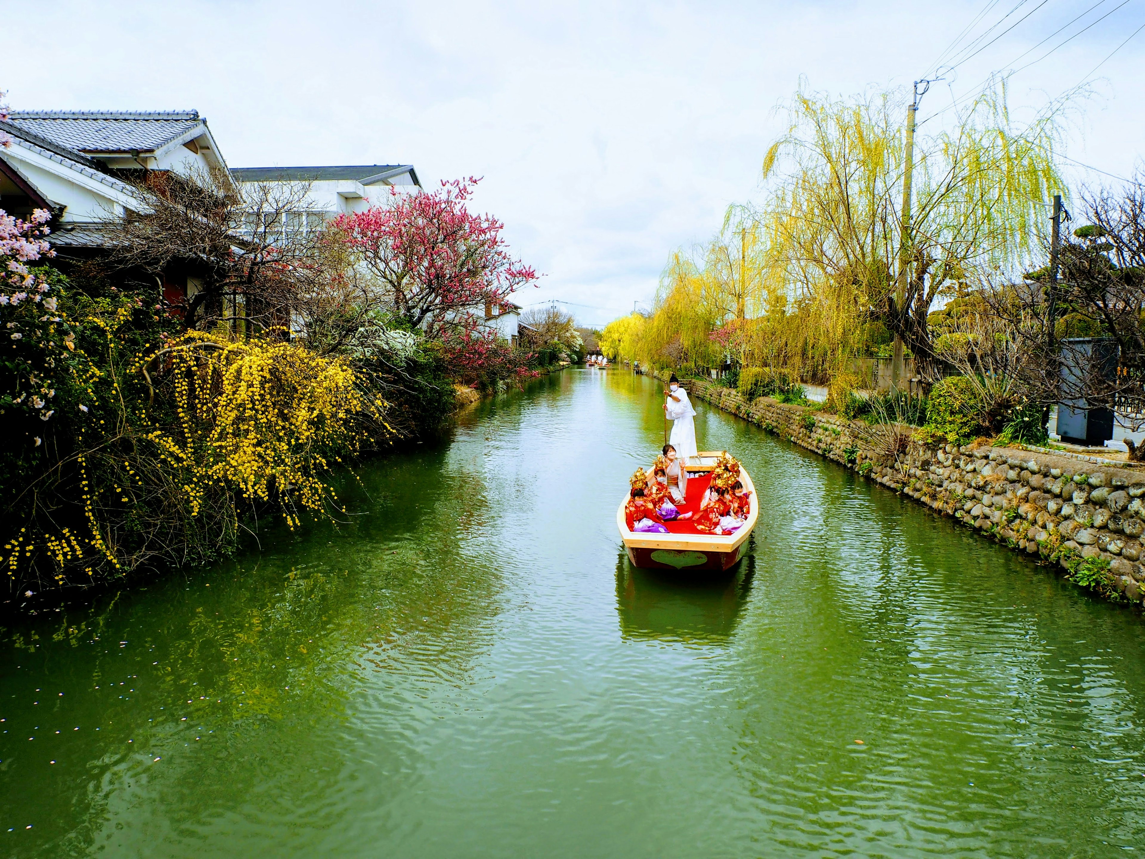 Scenic canal with a boat and vibrant flowers along the banks