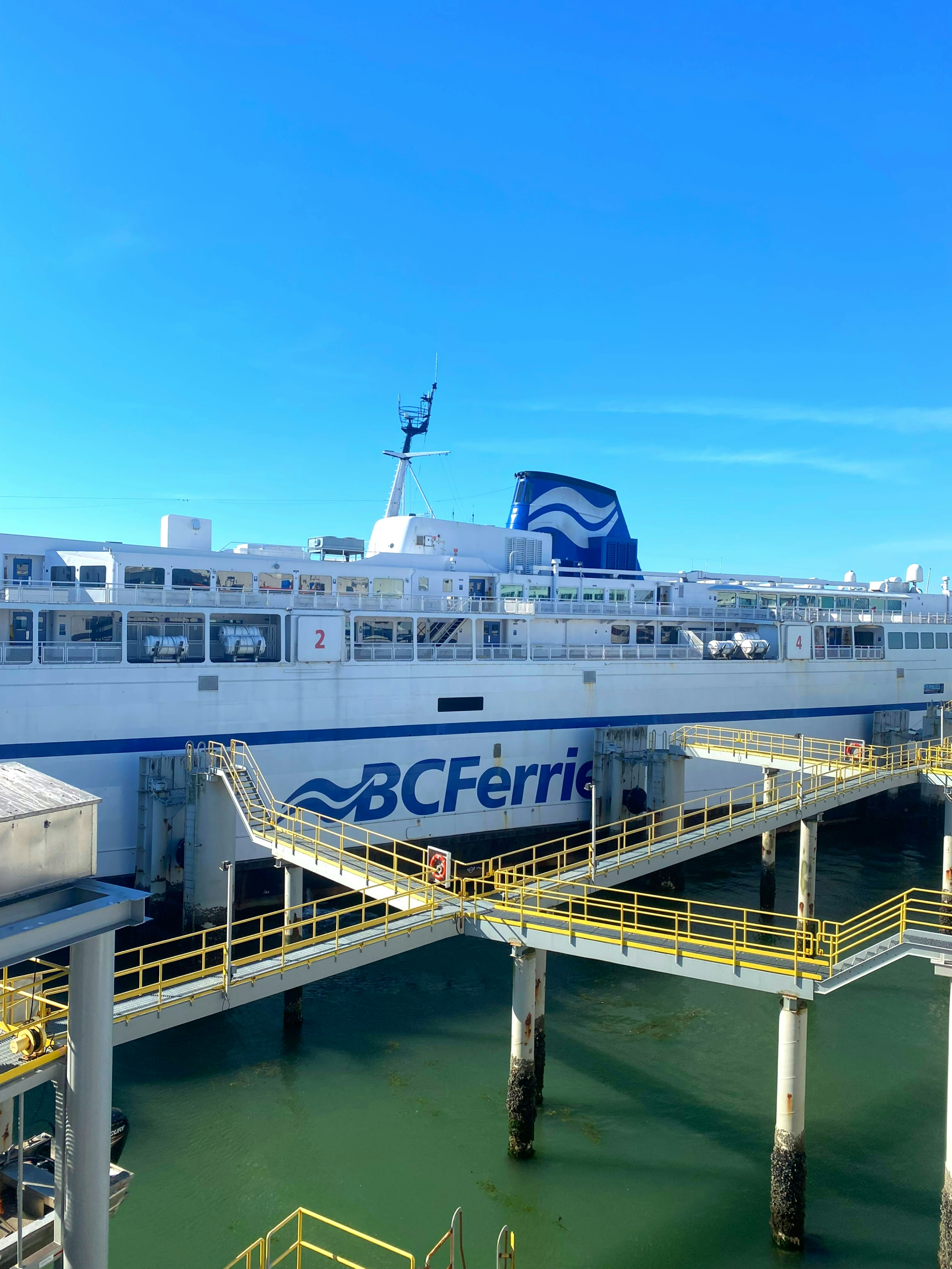 Buque de BC Ferries atracado en un muelle bajo un cielo azul claro