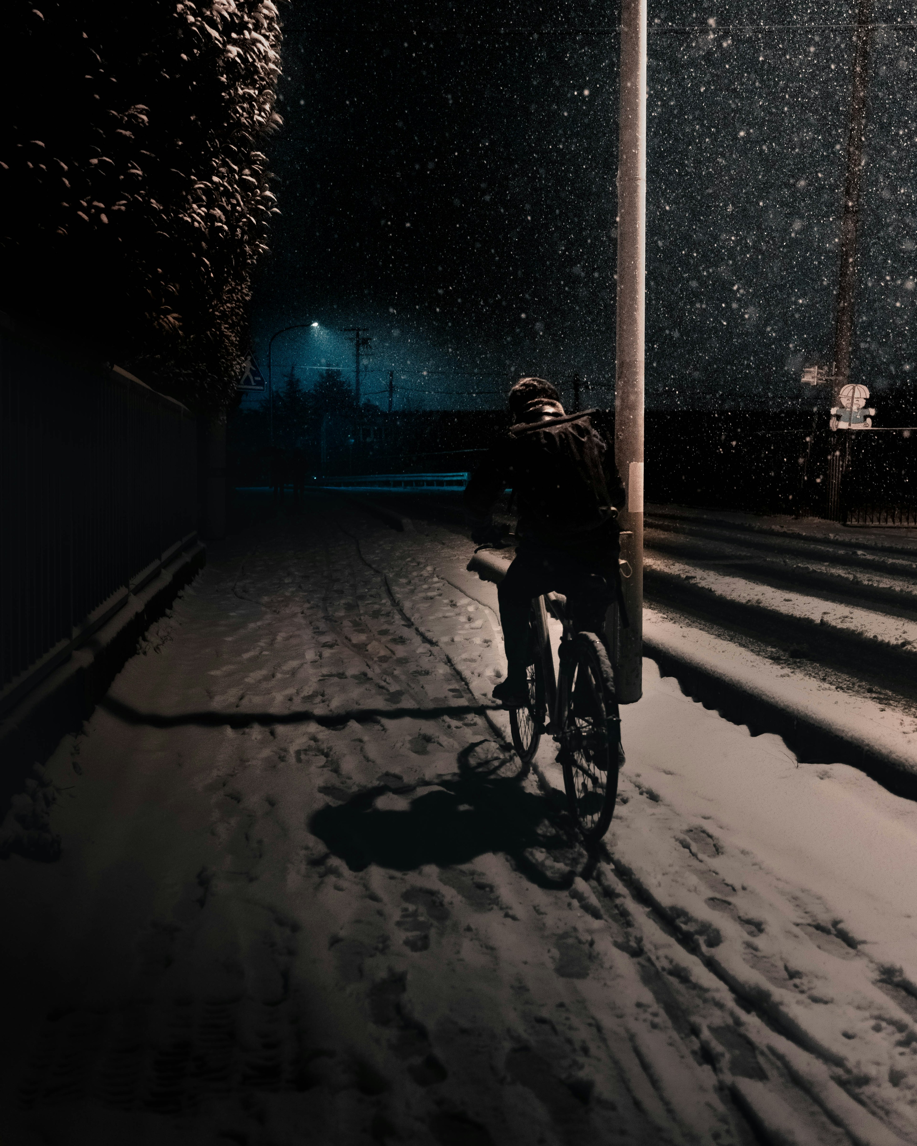 Person riding a bicycle in the snow at night