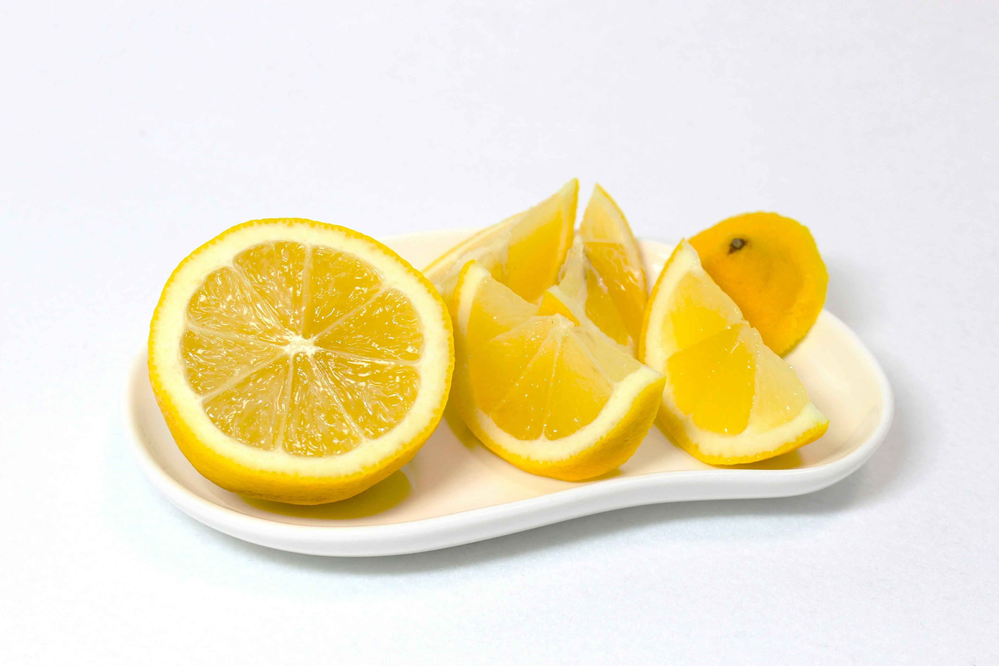 Tranches de citron frais et quartiers disposés sur une assiette blanche