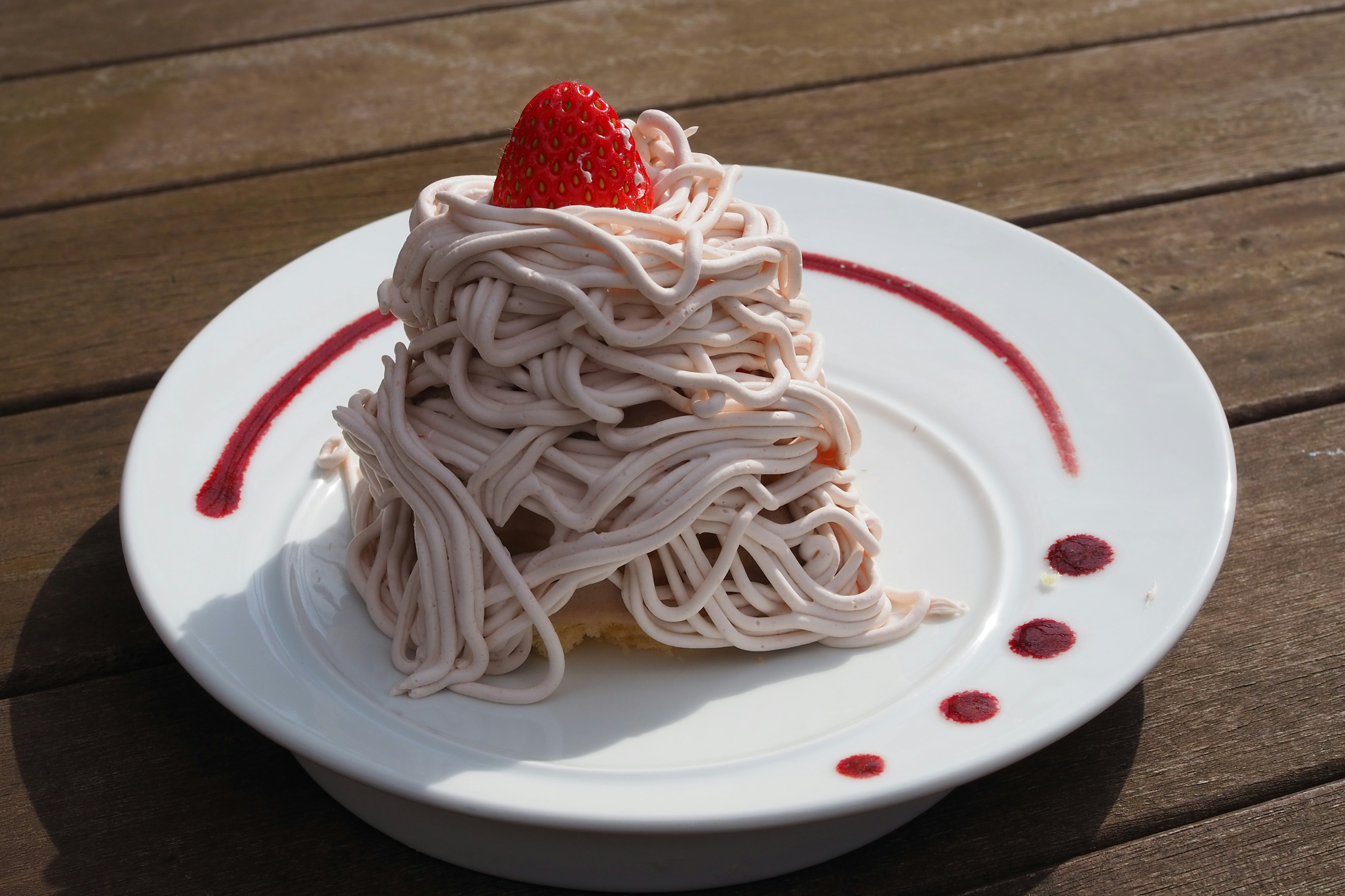 Gâteau Mont Blanc sur une assiette blanche avec une fraise sur le dessus