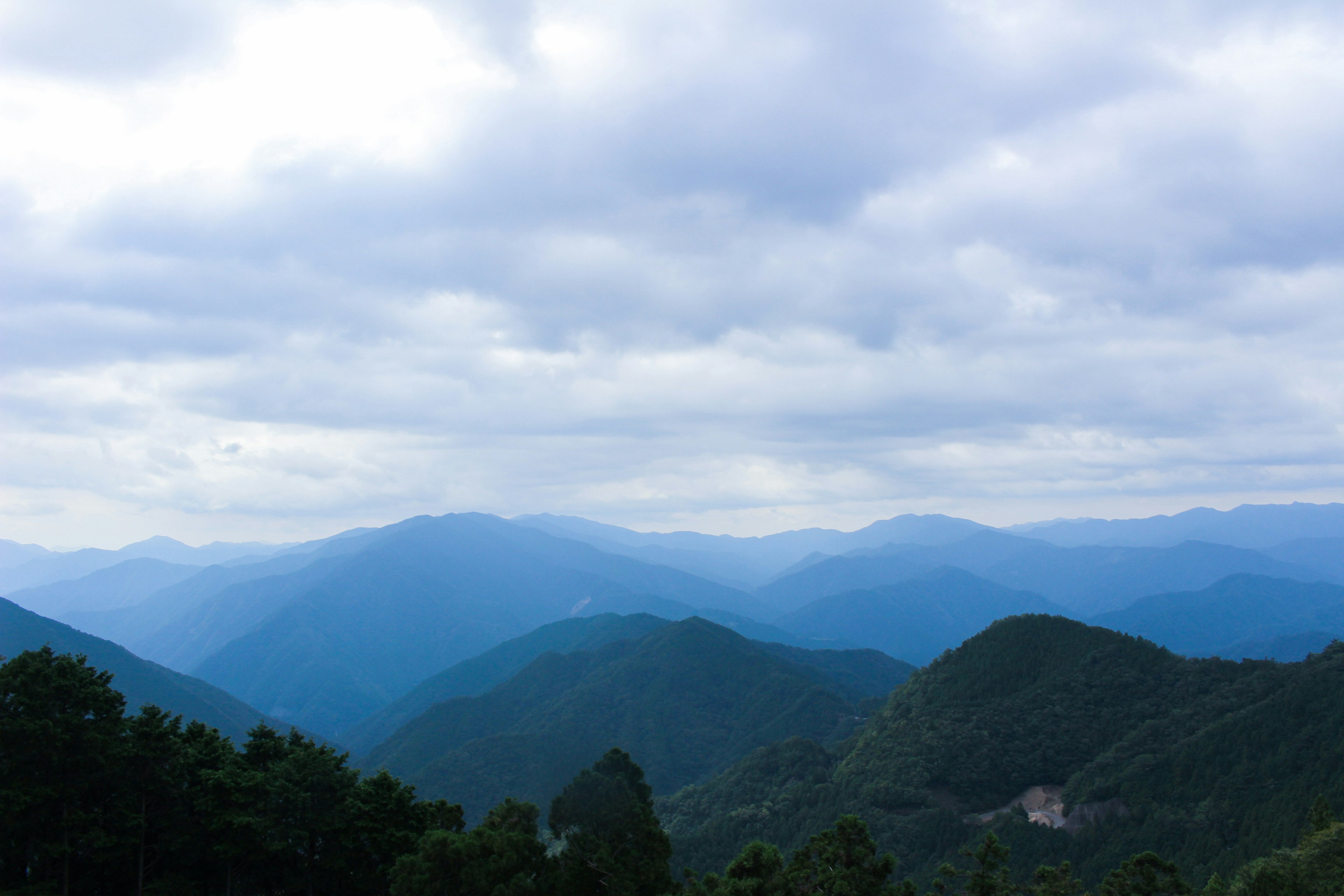 Pemandangan pegunungan biru di bawah langit mendung