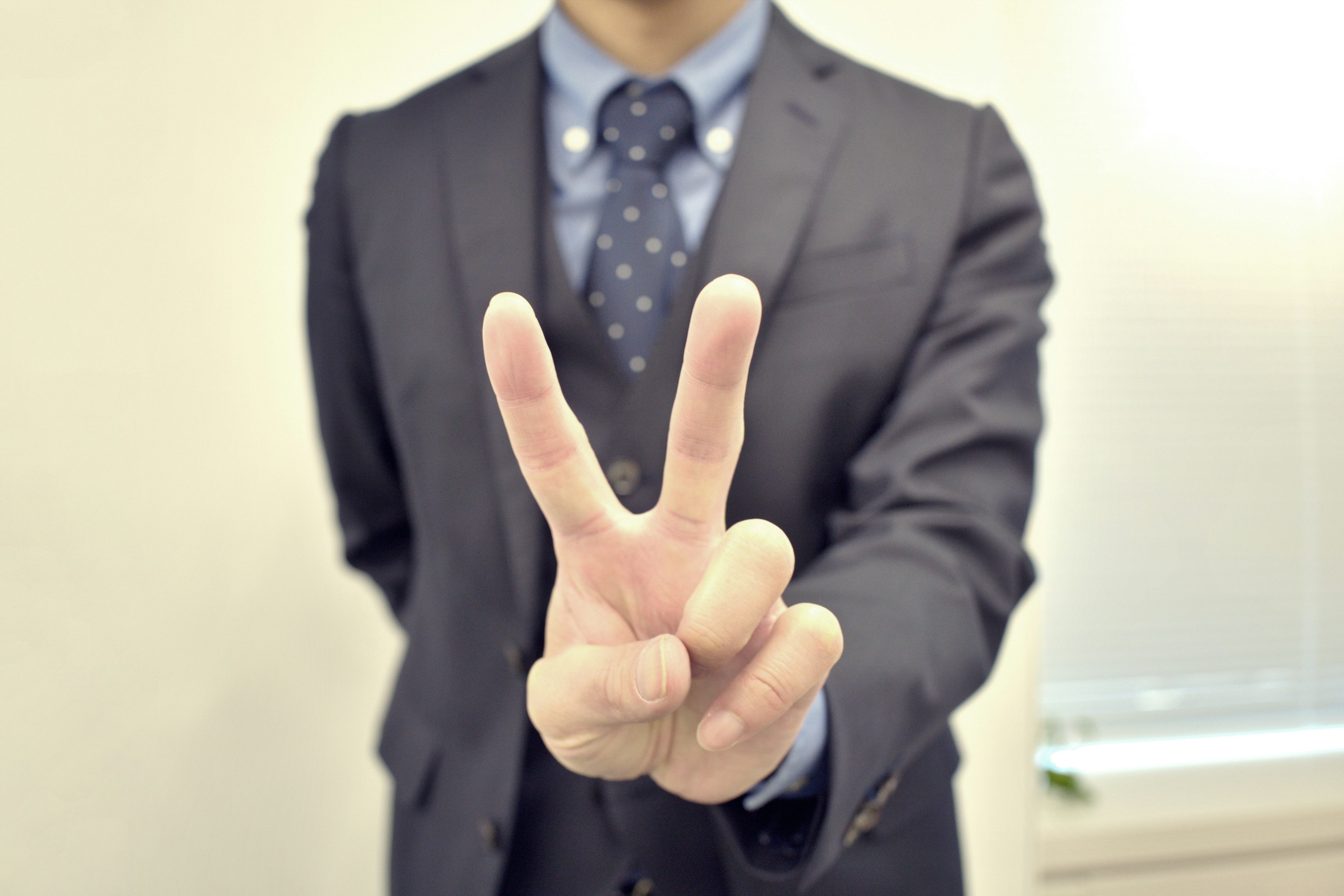 Hombre en traje haciendo un signo de paz