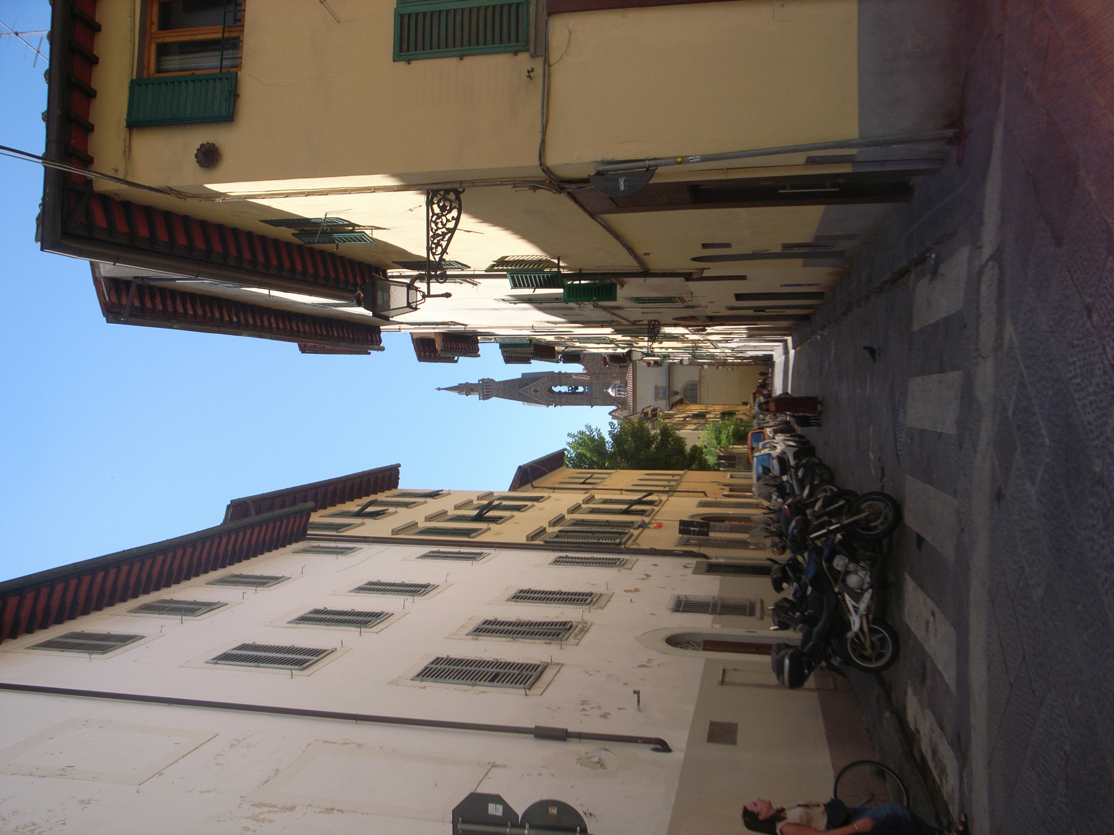 Narrow alley with parked motorcycles and historic buildings