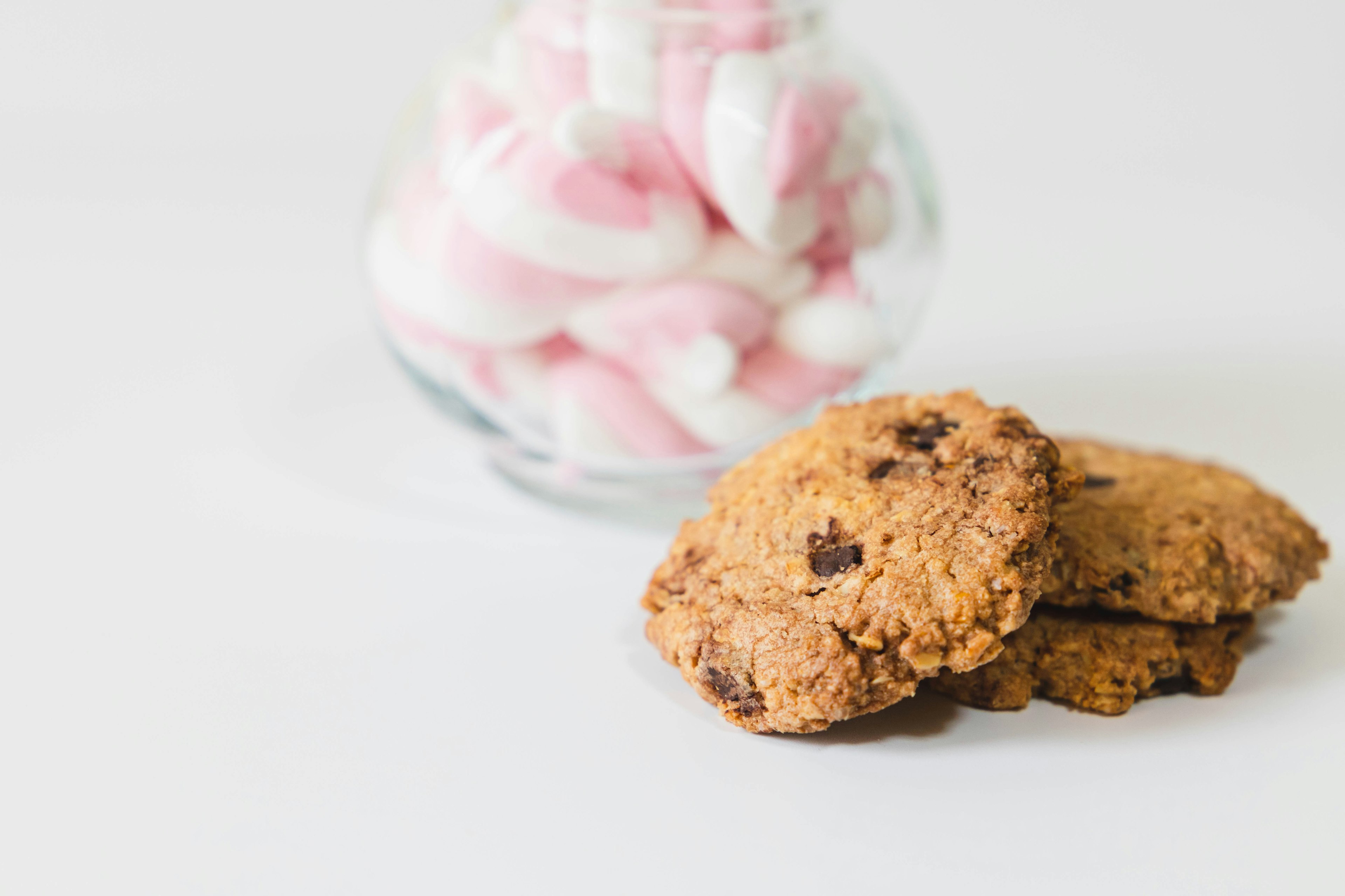 Image of cookies with a glass jar of marshmallows in the background