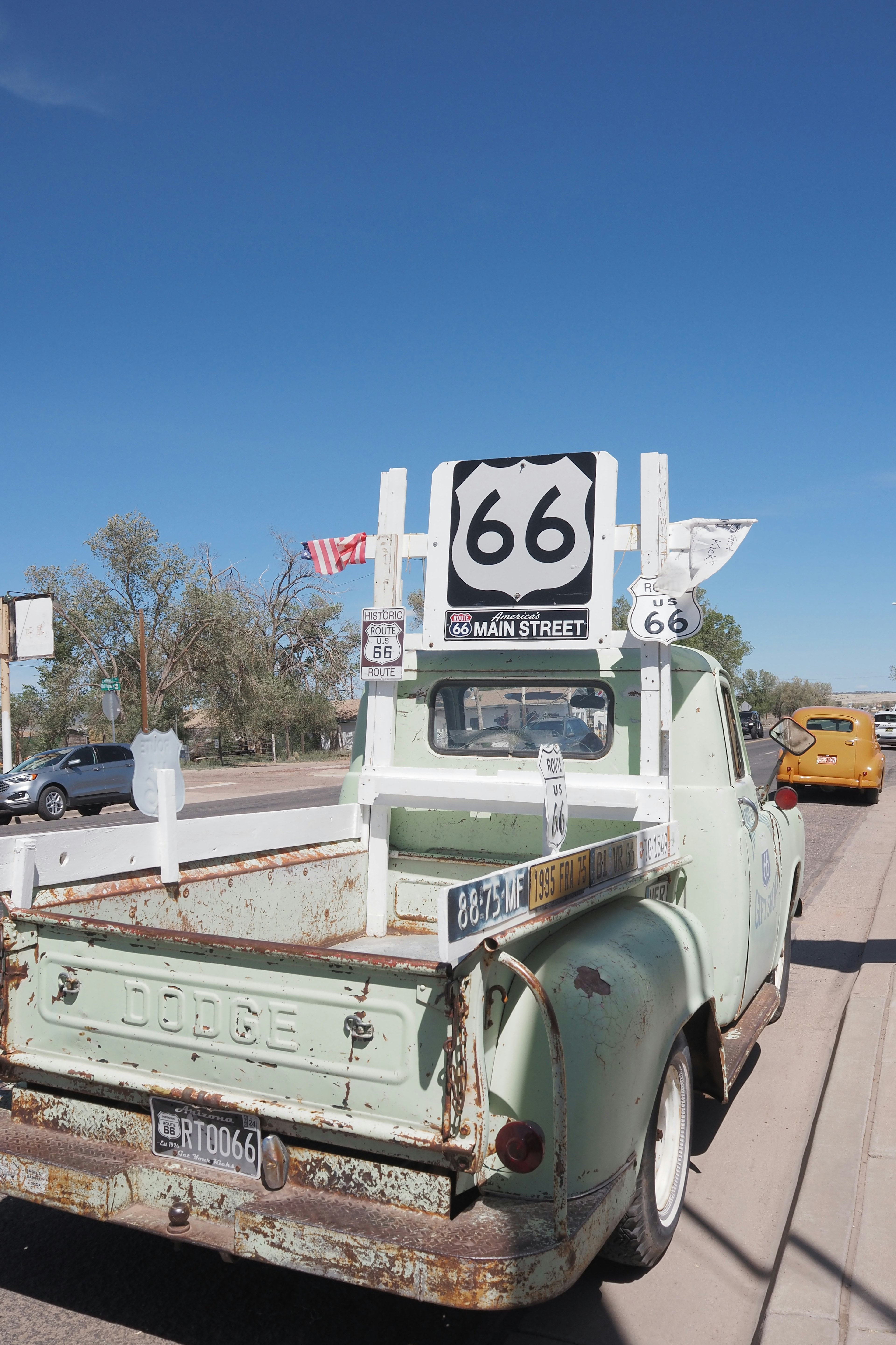 Vintage green Dodge truck displaying Route 66 sign