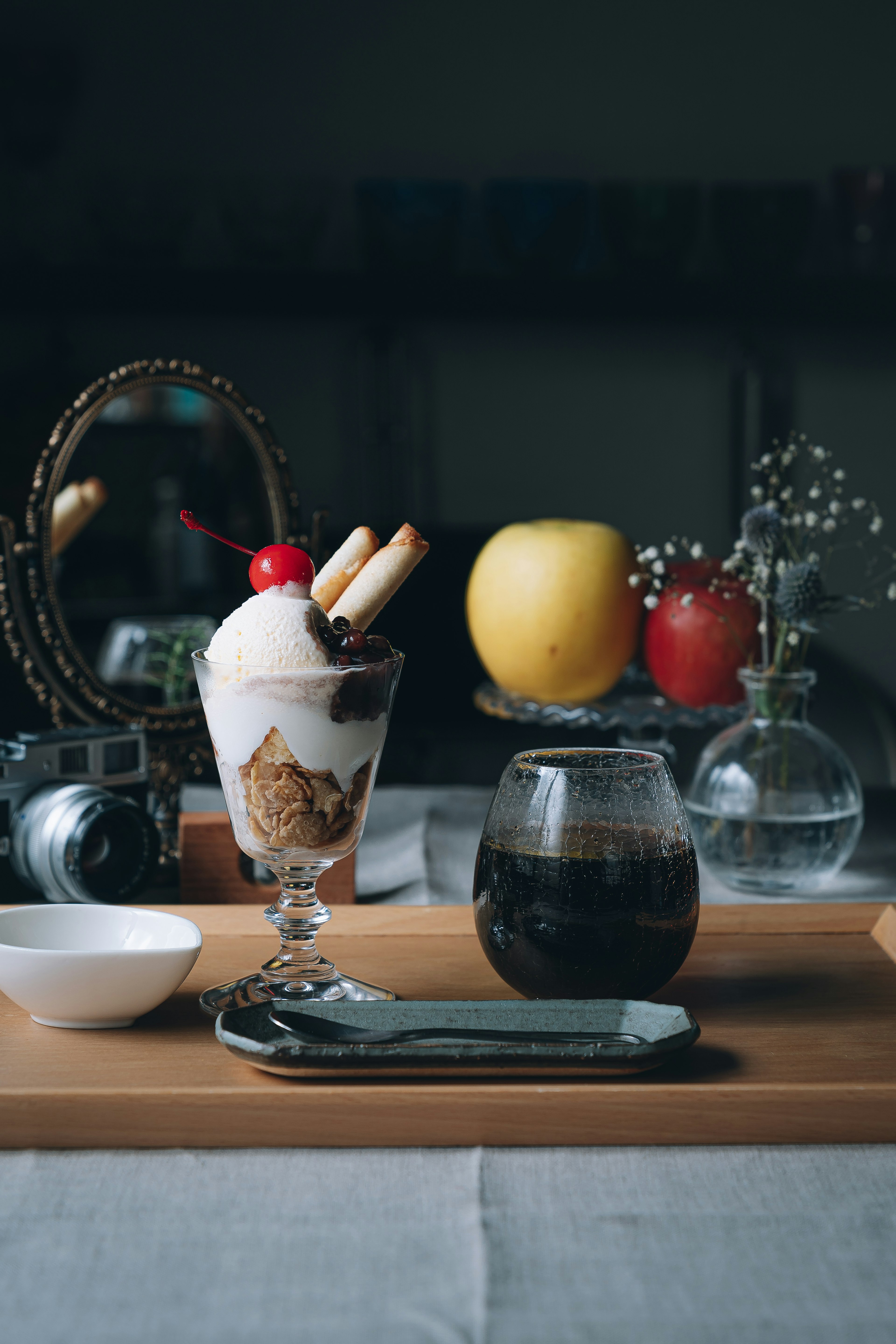 Dessert plate featuring ice cream sundae with cherry and coffee in glass