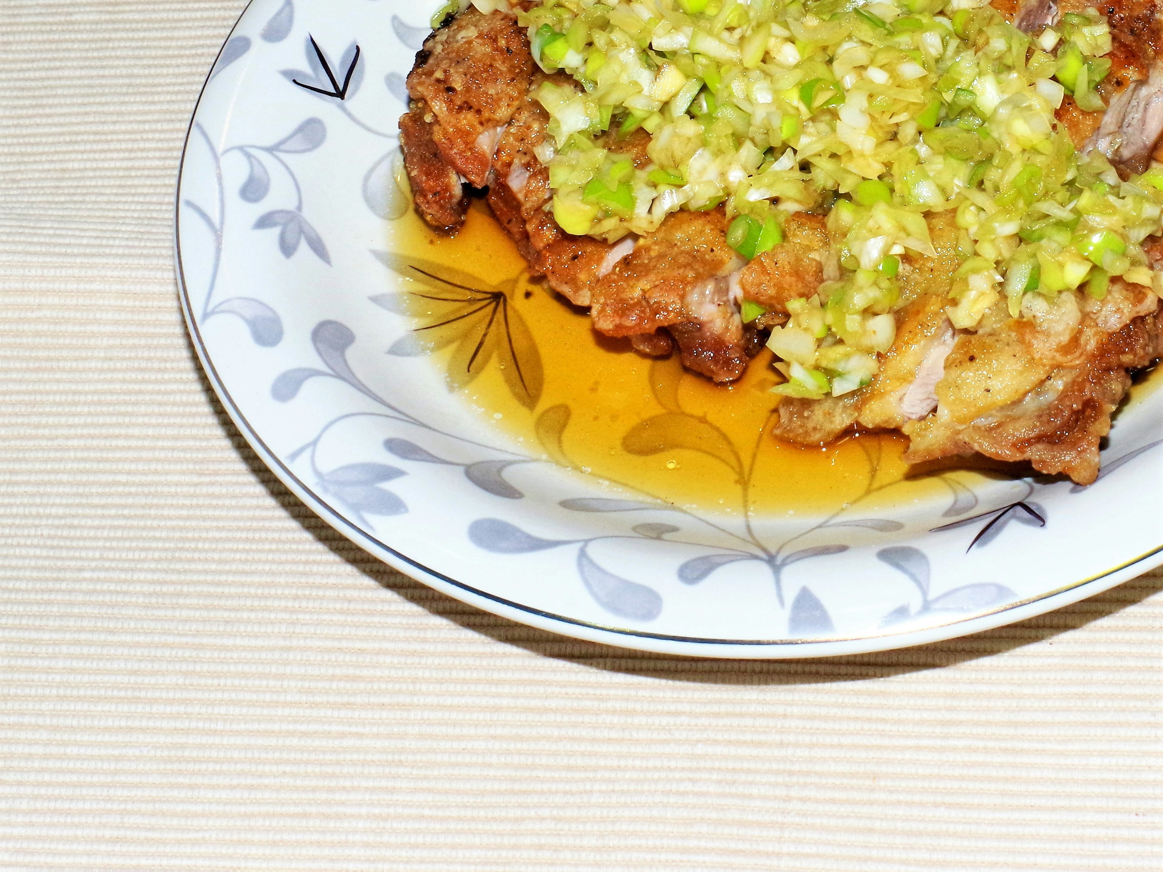 Pollo frito cubierto con salsa de cebolla verde