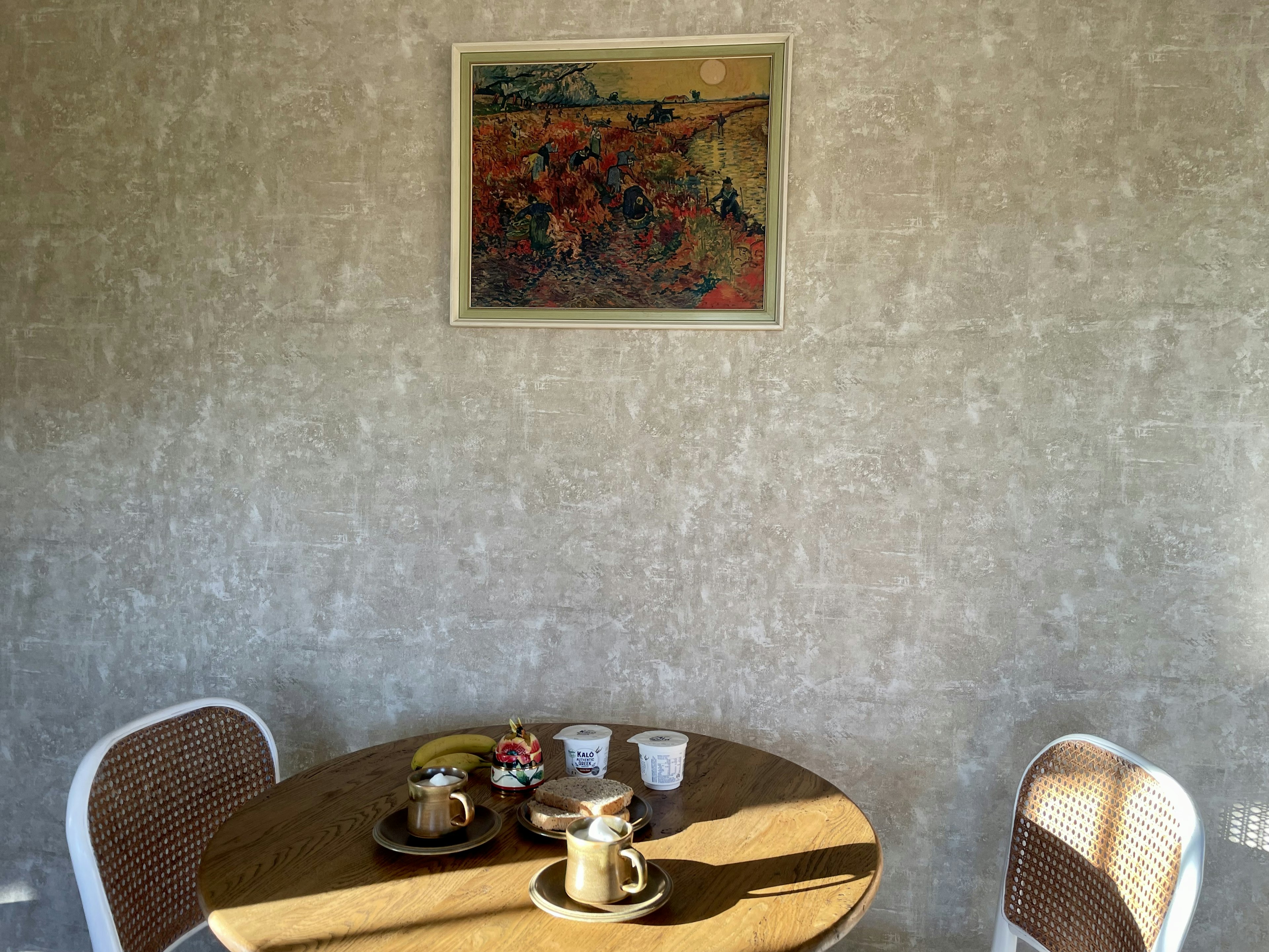 Un coin chaleureux avec une table préparée pour le café et des sucreries avec une peinture colorée au mur