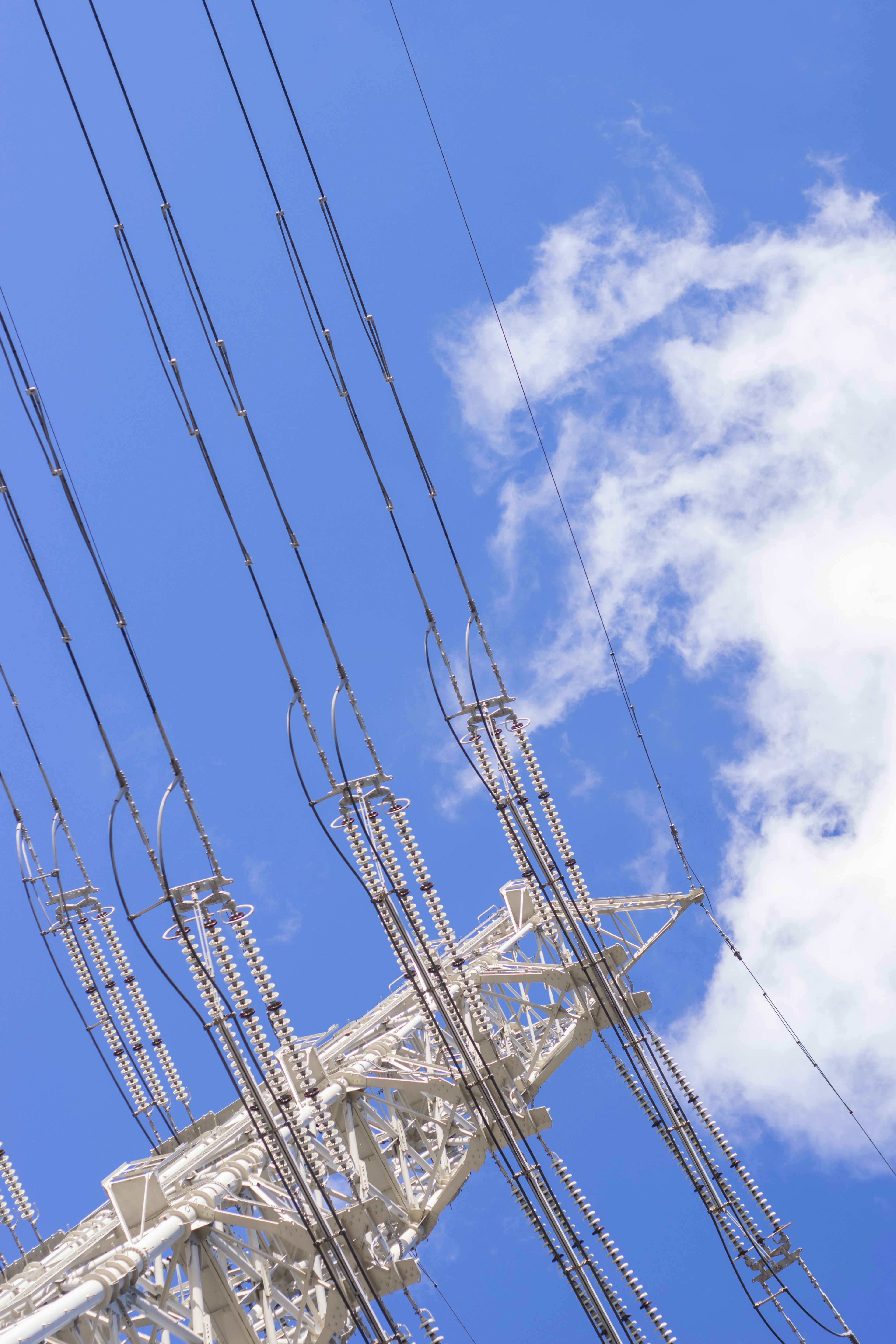 Palo elettrico e cavi contro un cielo blu