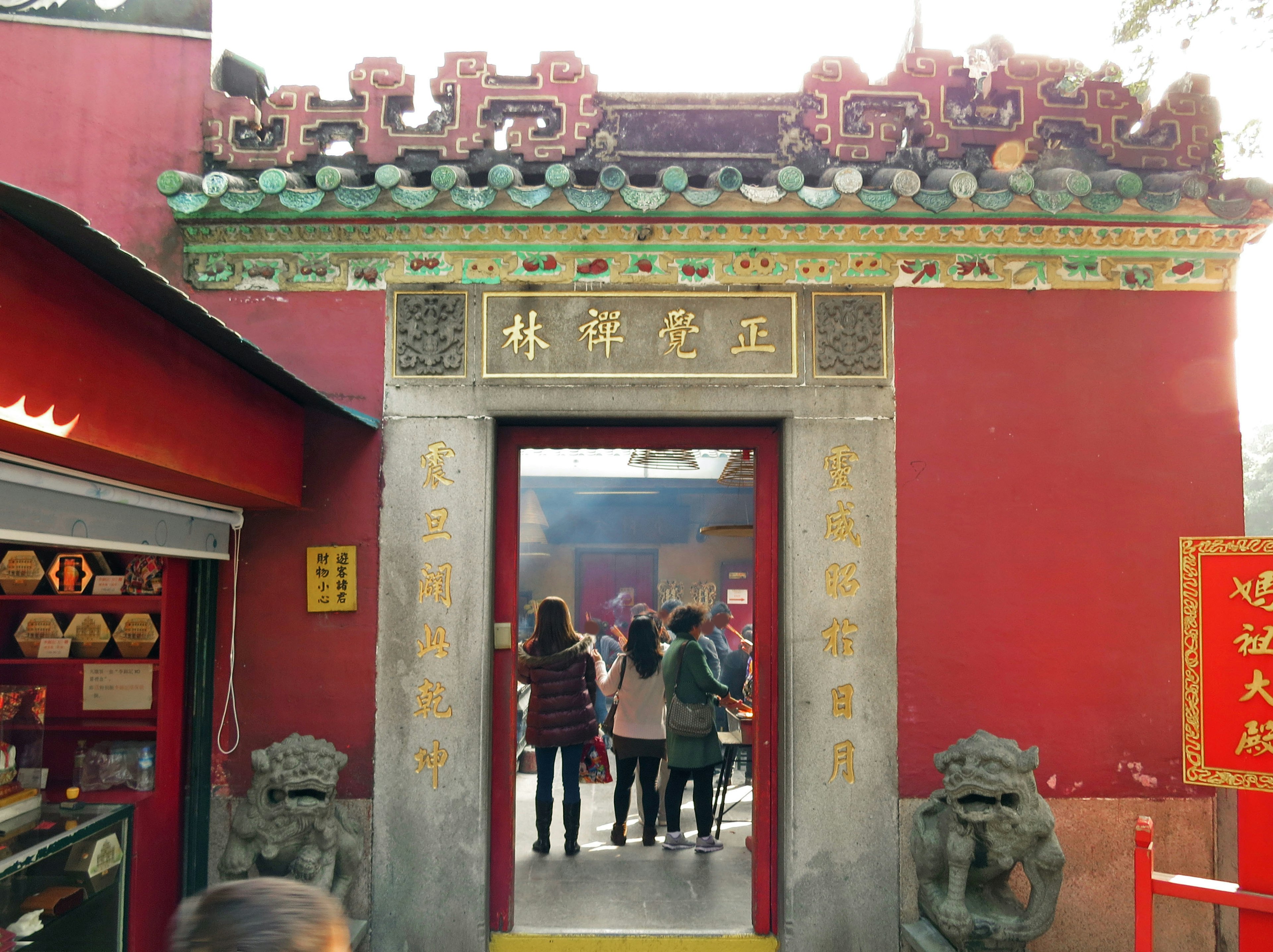 Entrada de un templo tradicional con paredes rojas y esculturas de leones