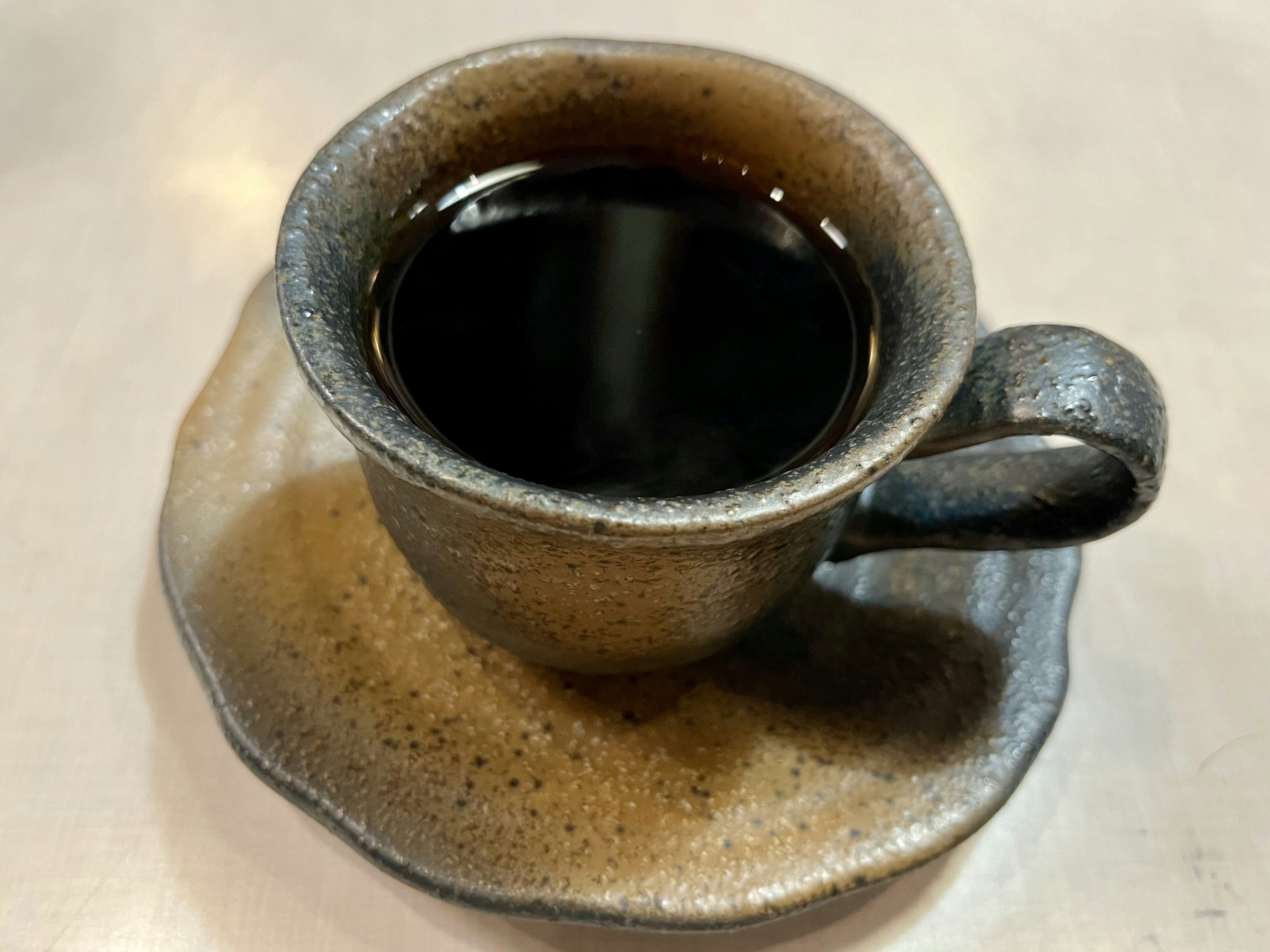 黒いコーヒーが注がれた独特な陶器のカップと皿