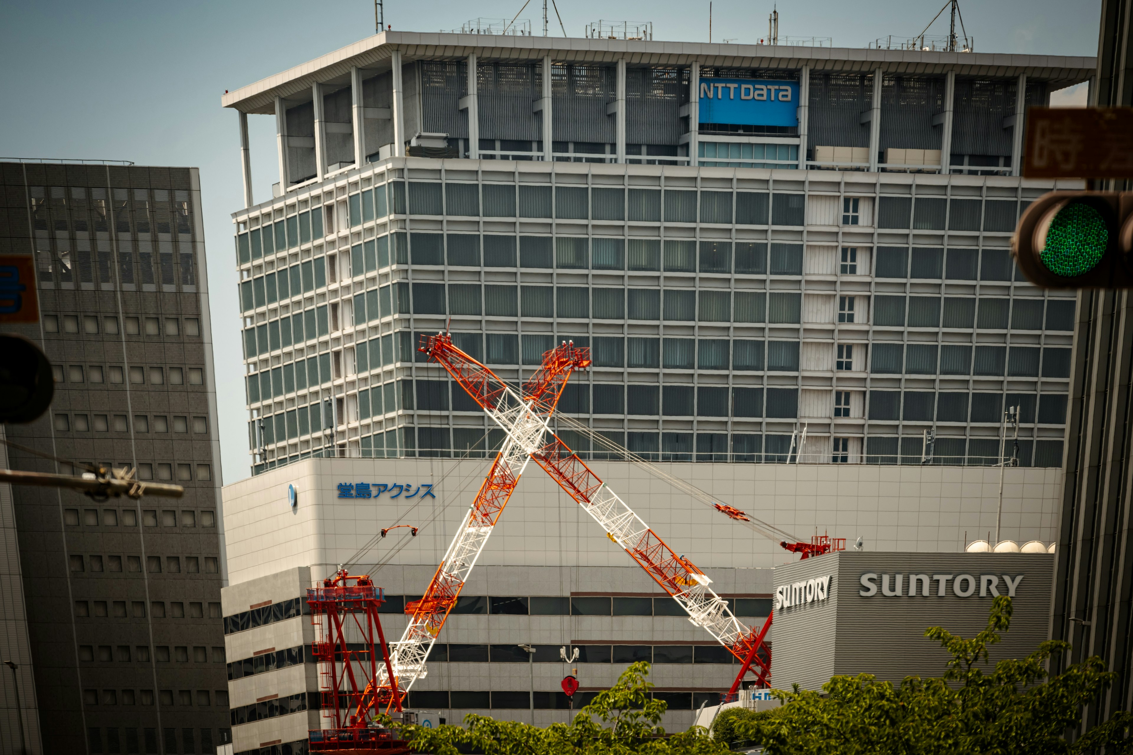 Sitio de construcción del edificio Suntory con grúas rojas cruzadas