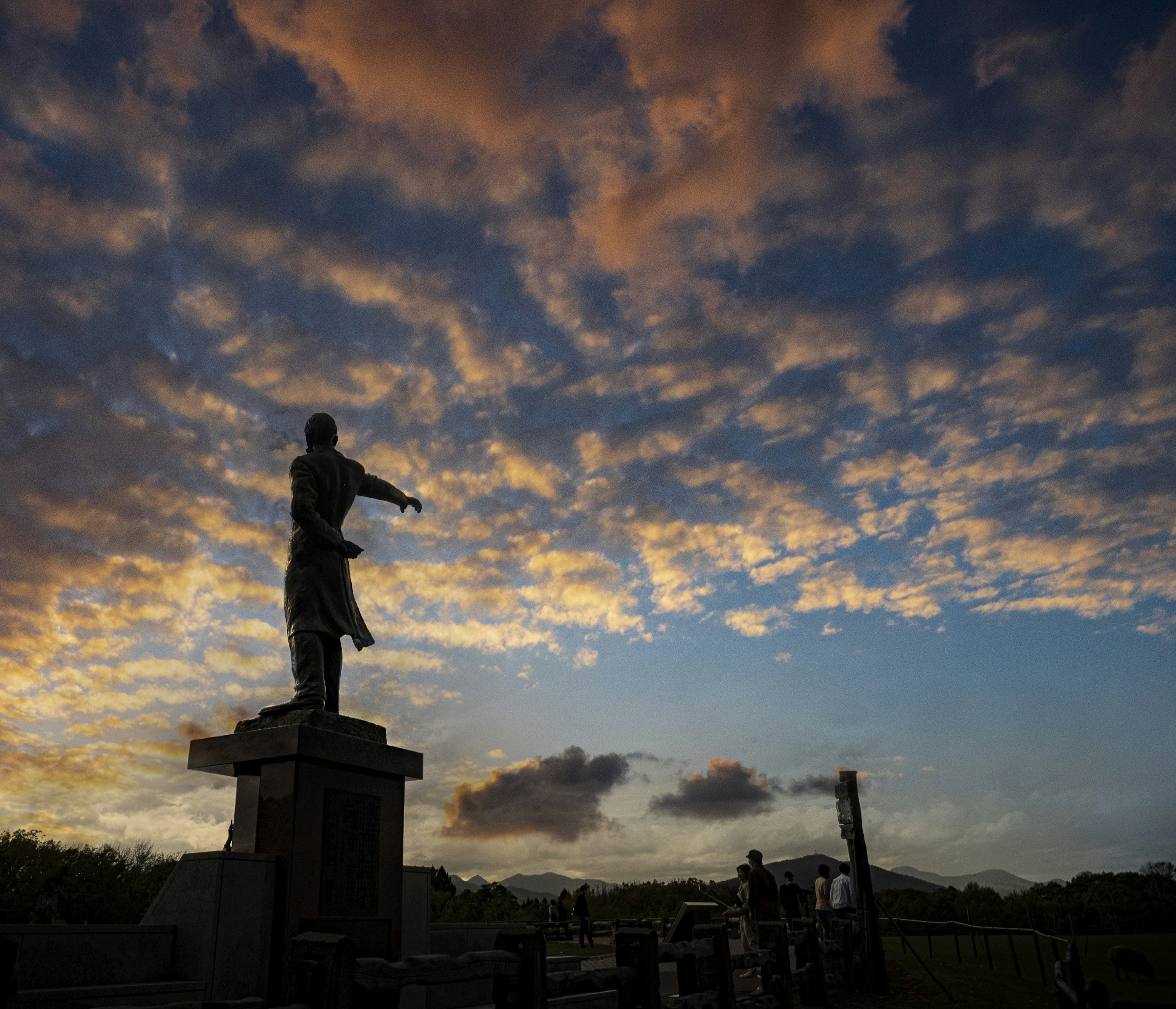 Silhouette d'une statue contre un ciel de coucher de soleil coloré