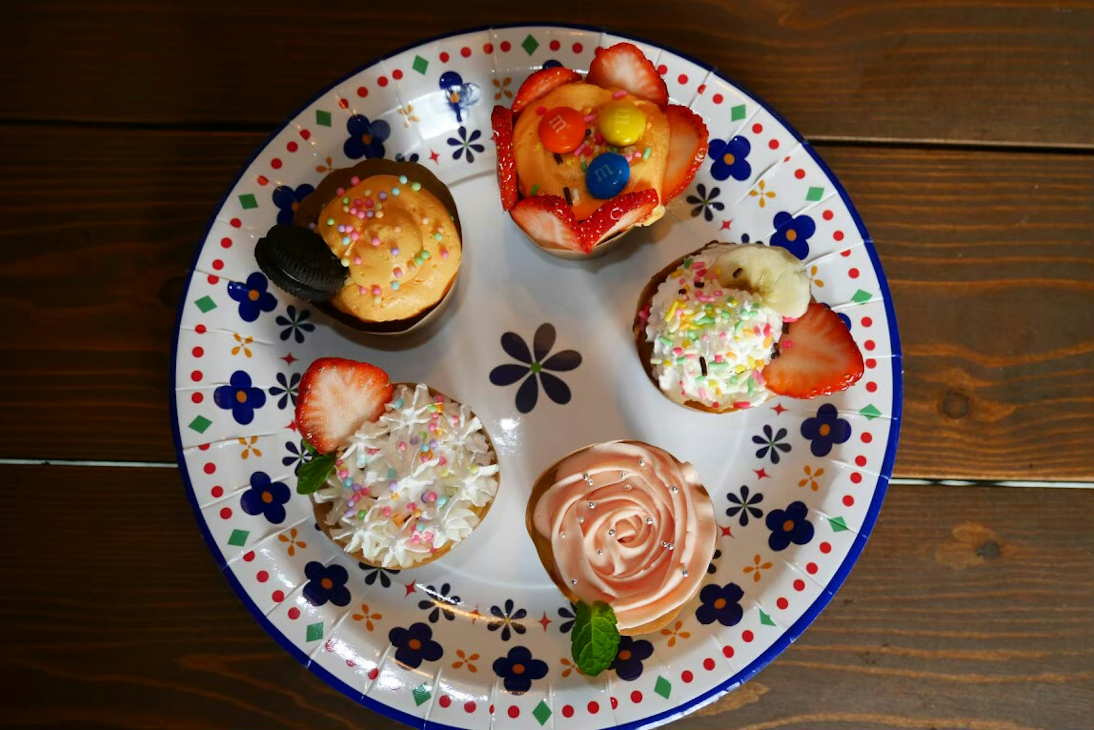 A plate displaying colorful cupcakes with various toppings