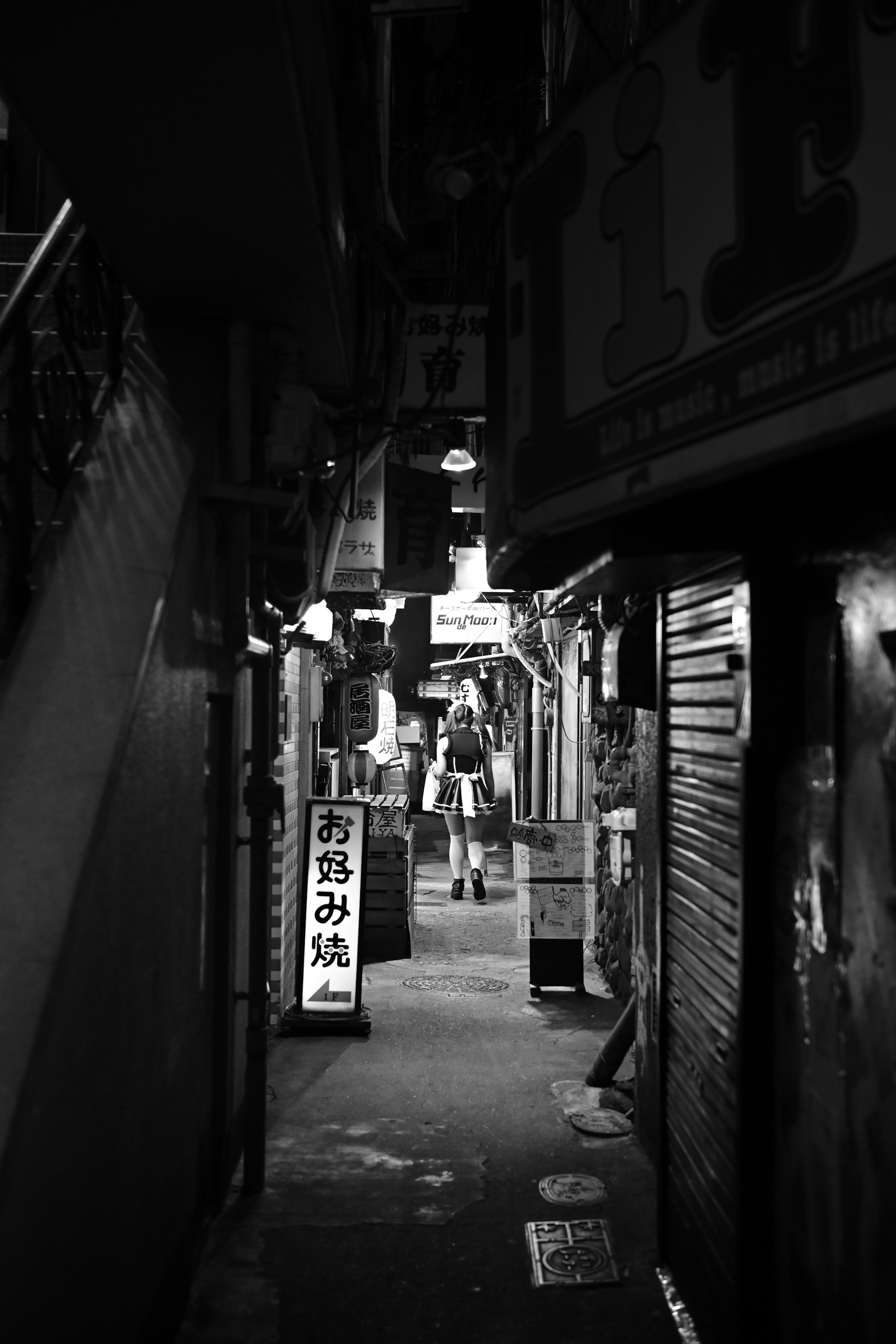 Narrow alleyway with signs and a dark atmosphere