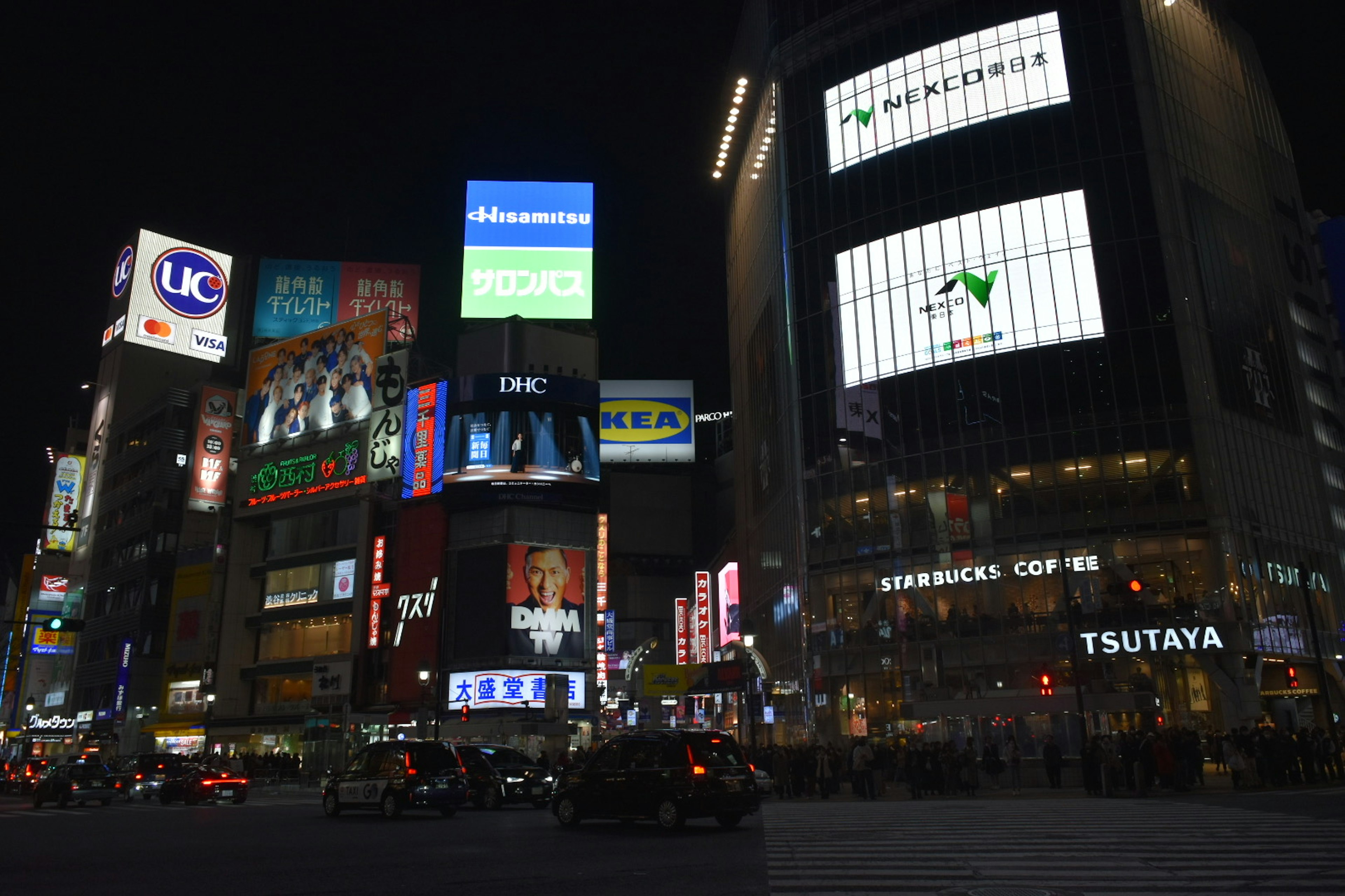 Night scene of Shibuya with neon signs and crowds of people