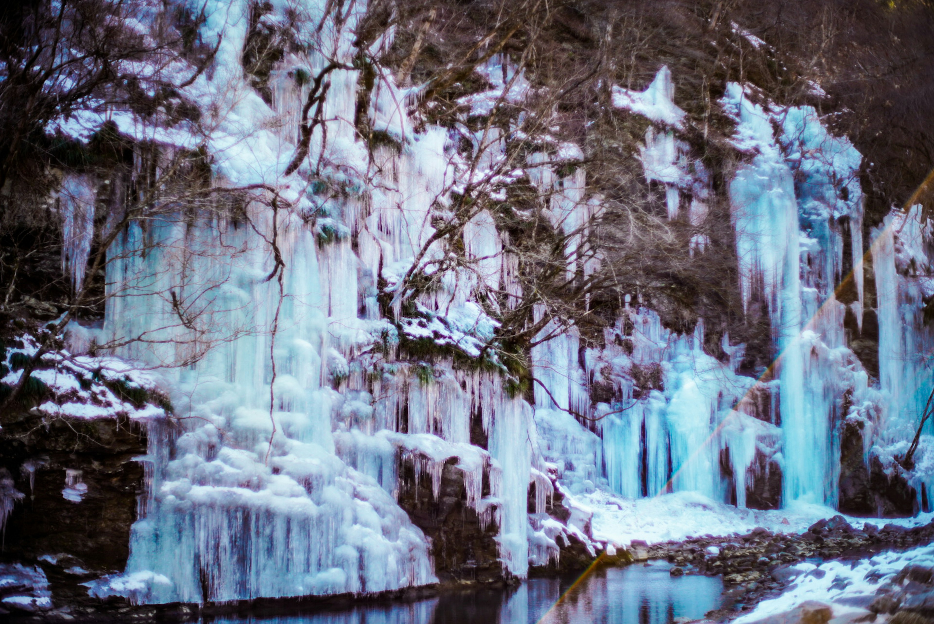 Paesaggio invernale con cascate di ghiaccio e formazioni rocciose ghiacciate