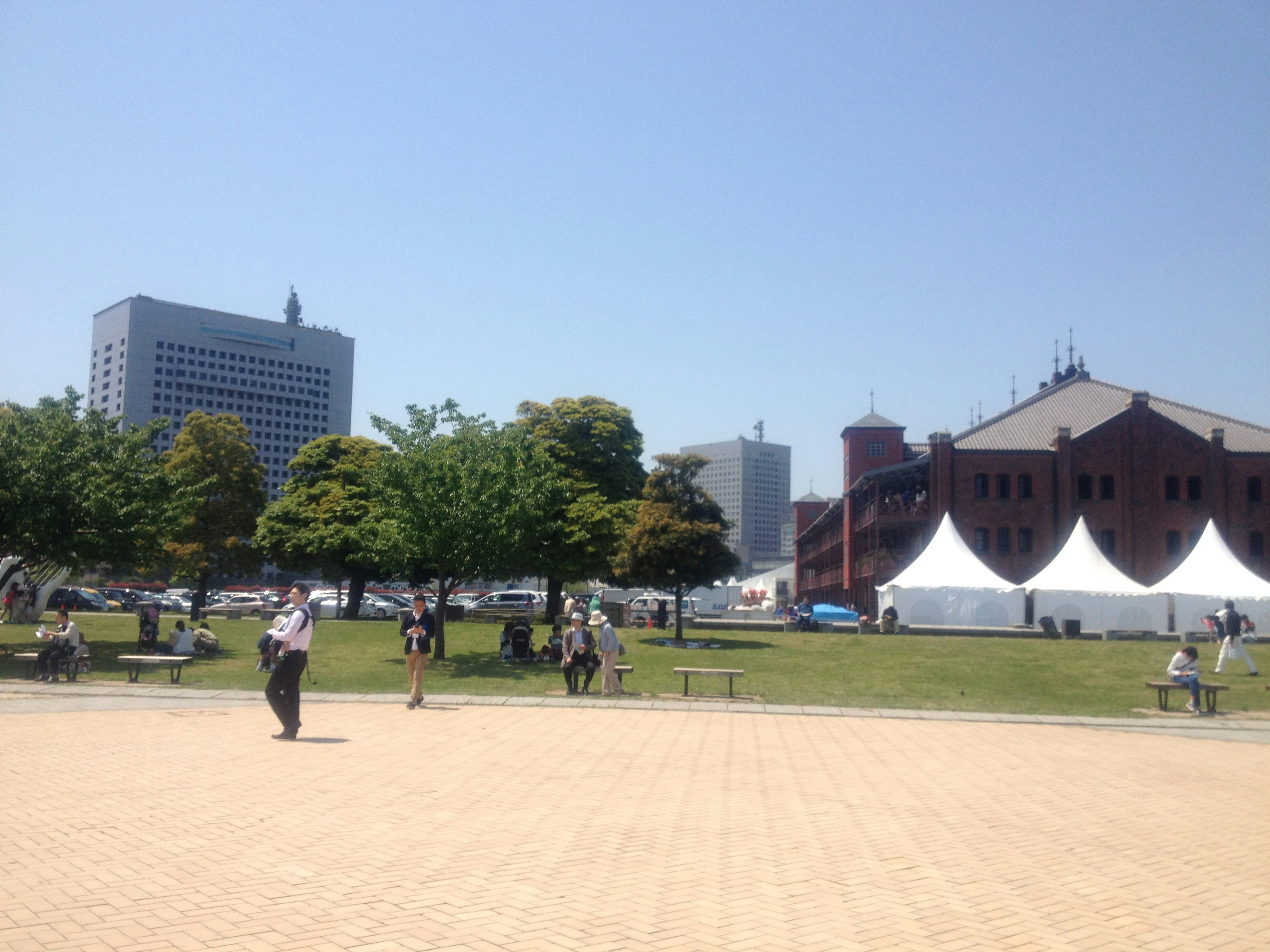 Parkszene unter klarem blauen Himmel mit modernen Gebäuden und historischer Architektur