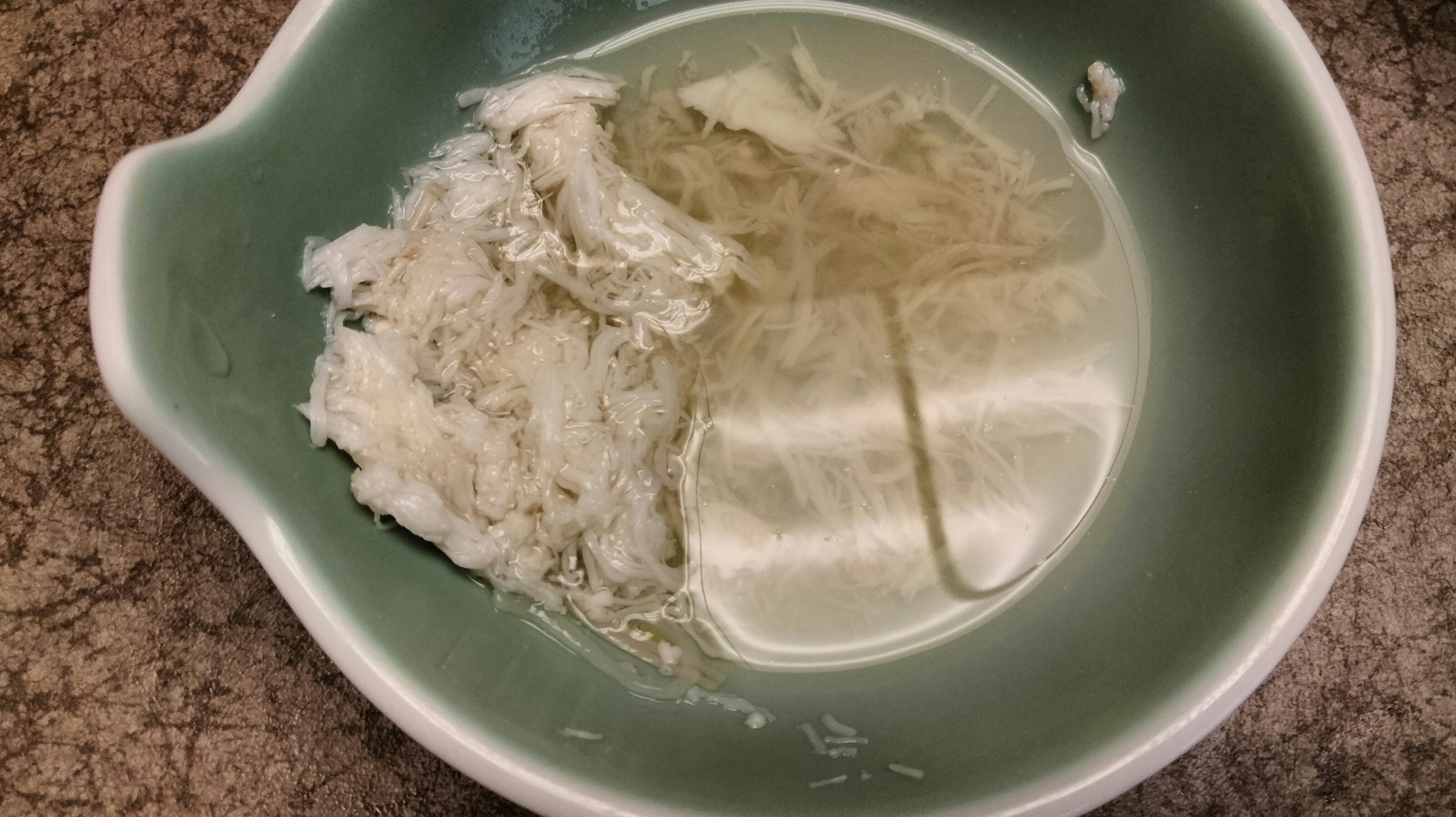 A blue bowl containing white rice and clear broth