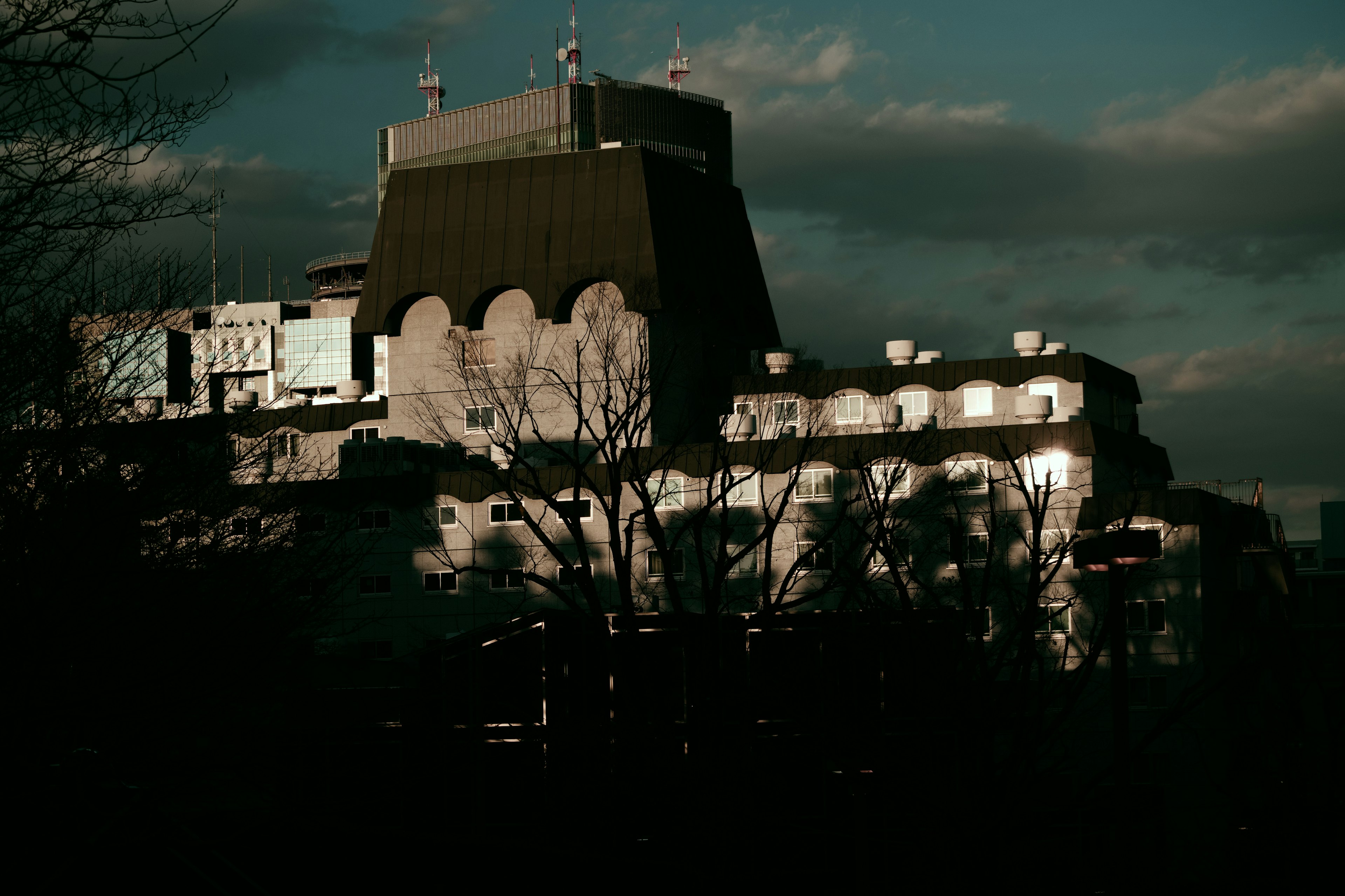 Silhouette d'un bâtiment sur fond sombre avec un toit distinctif