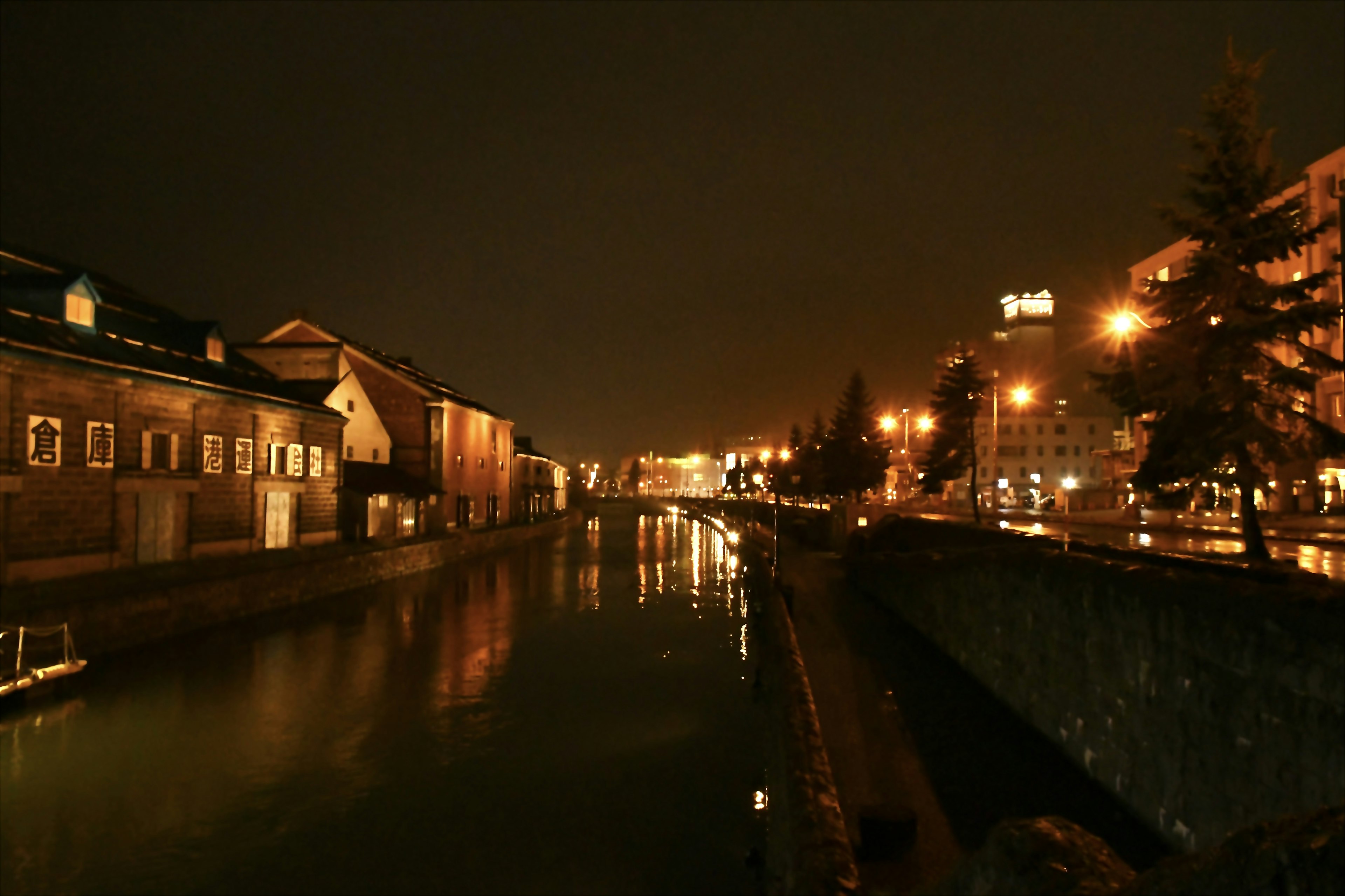 Vista nocturna de un canal con edificios y farolas