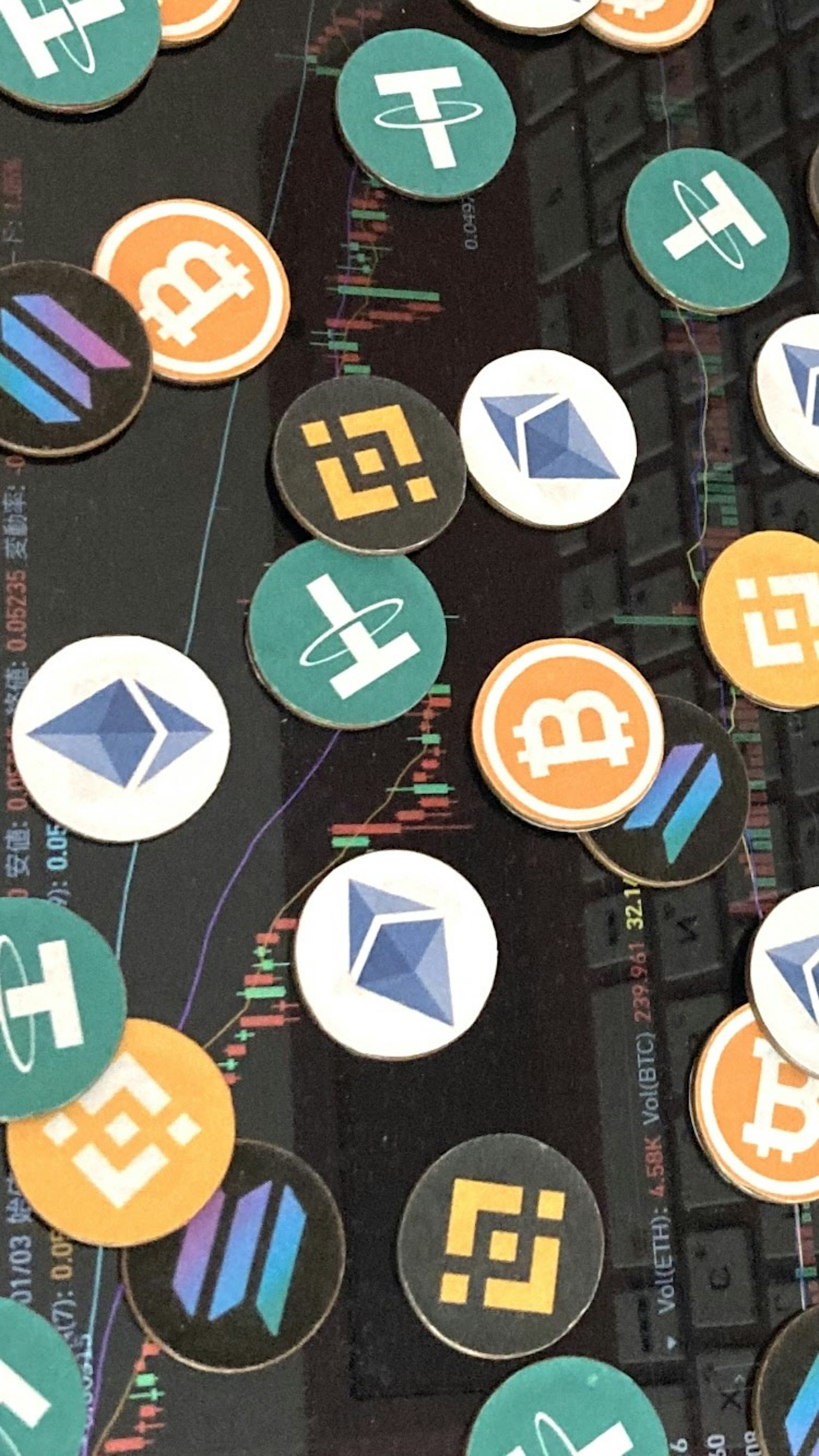 An array of cryptocurrency logos including Bitcoin and Ethereum scattered over a keyboard