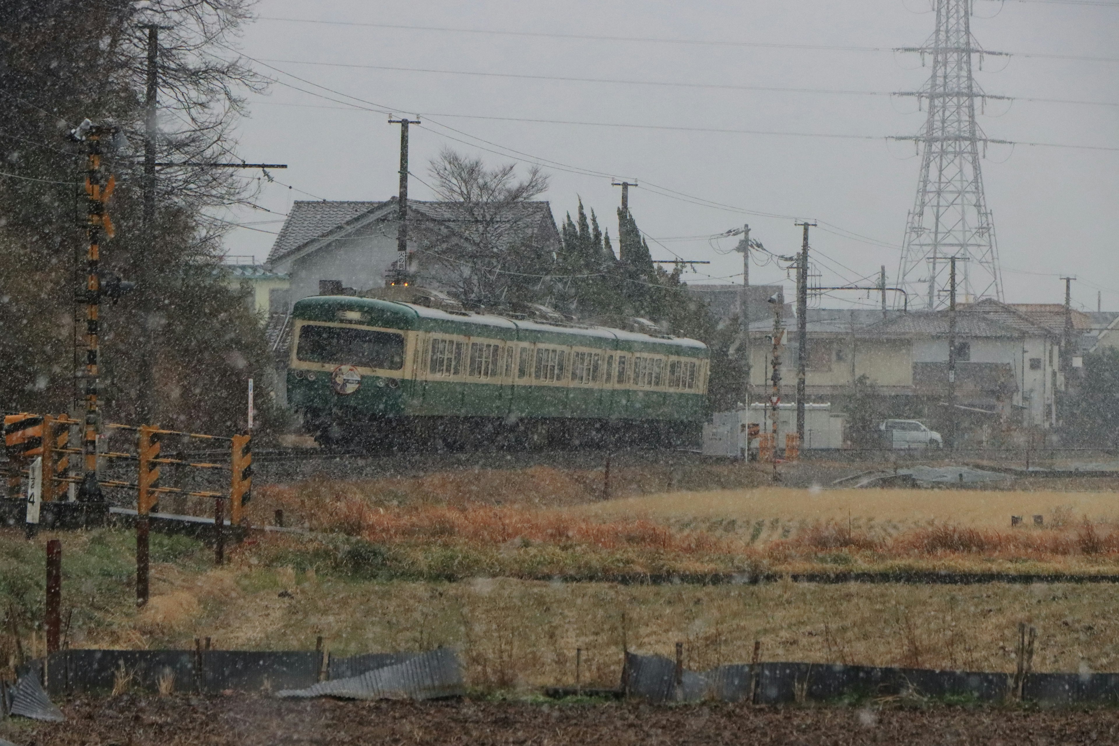 Train vert circulant sous la neige avec paysage rural