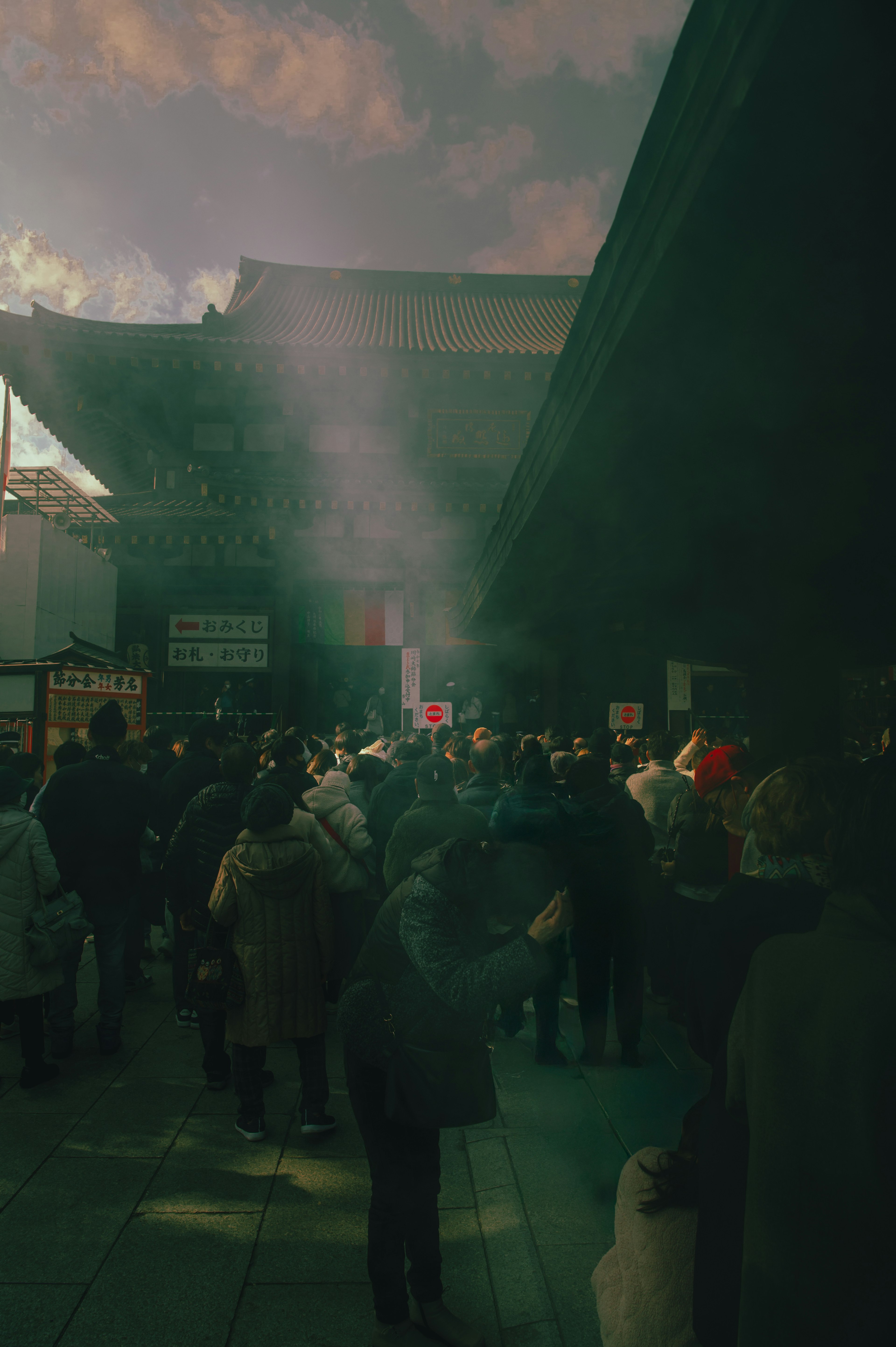 Foule rassemblée devant un temple avec de la fumée s'élevant