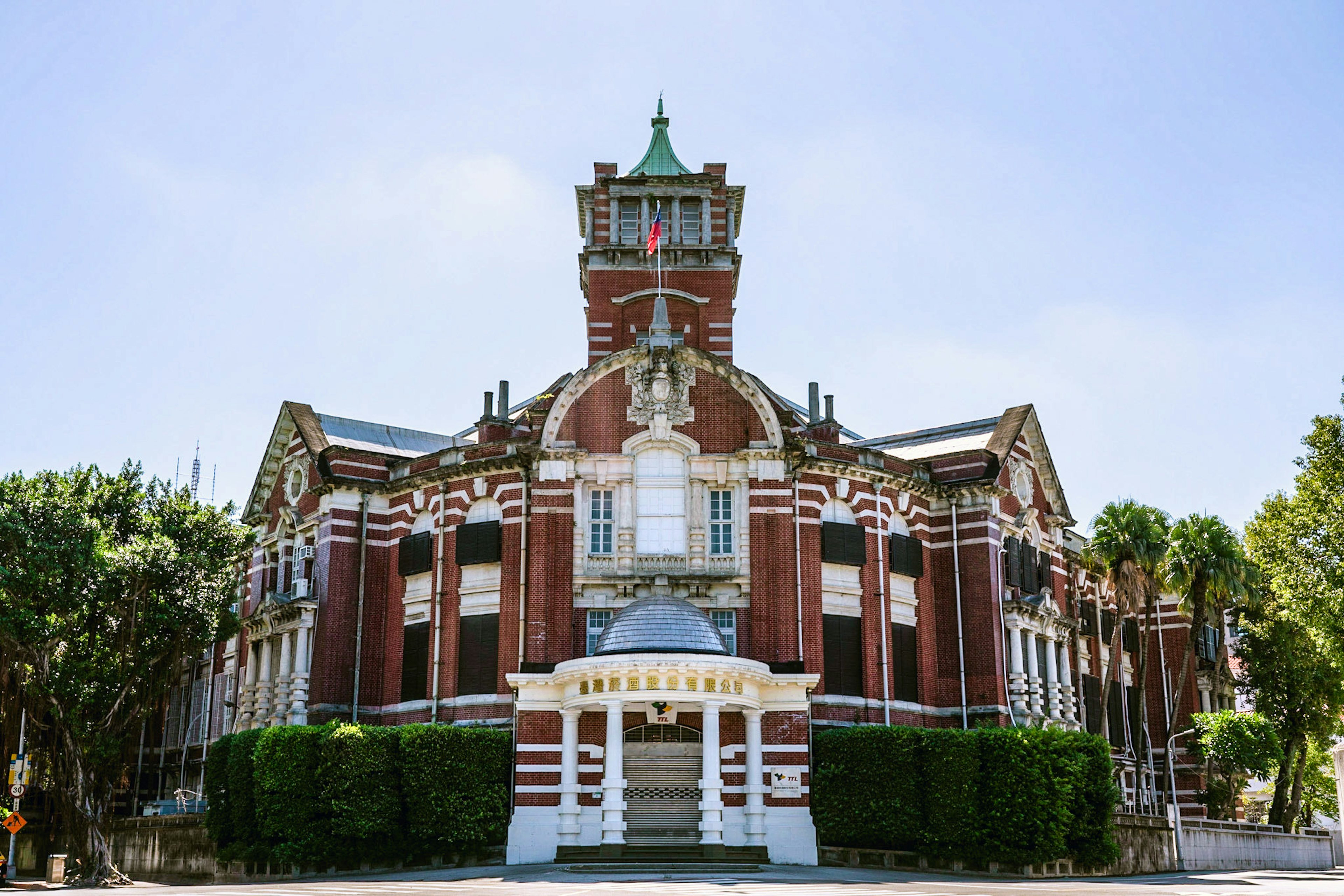 Historic brick building with a clock tower under a clear blue sky