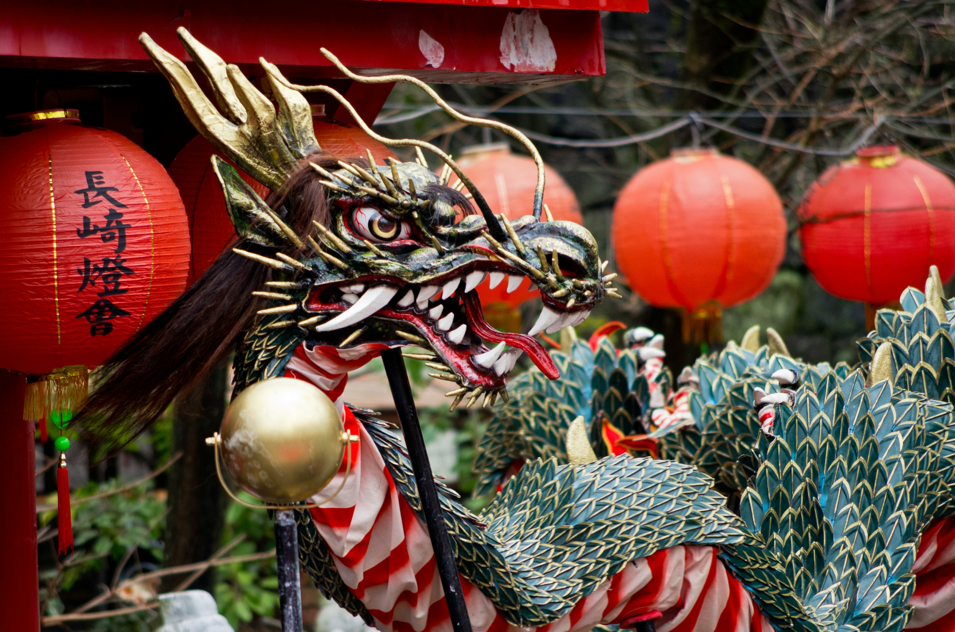 Statue de dragon colorée avec des lanternes rouges en arrière-plan