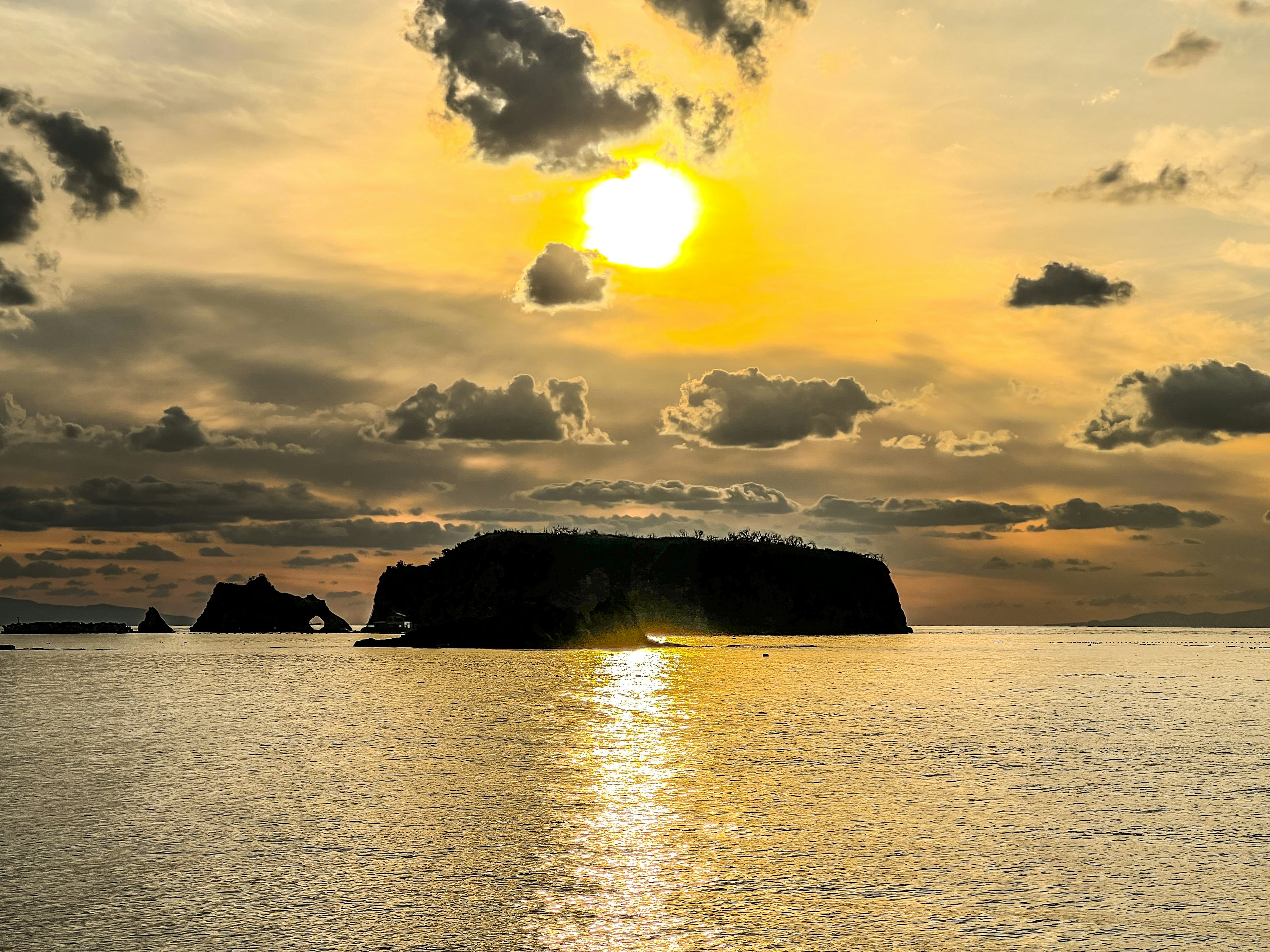 Sonnenuntergang über dem Ozean mit Silhouette einer Insel