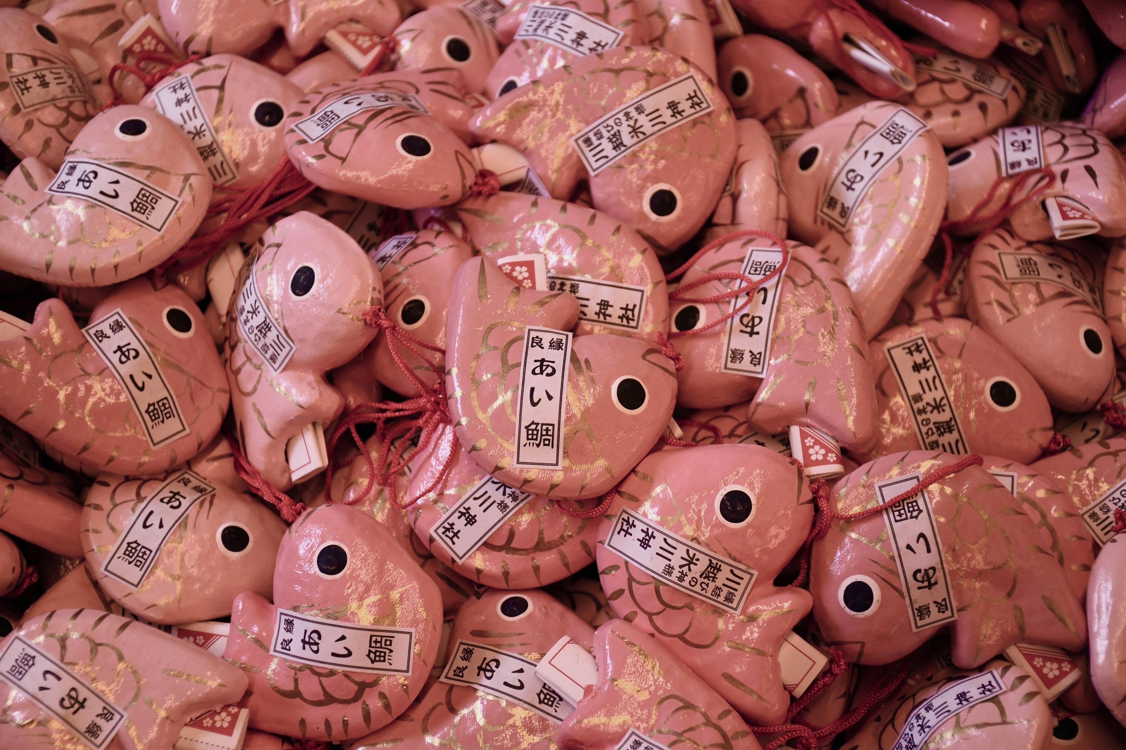 Une collection de charms en forme de poisson rose empilés ensemble