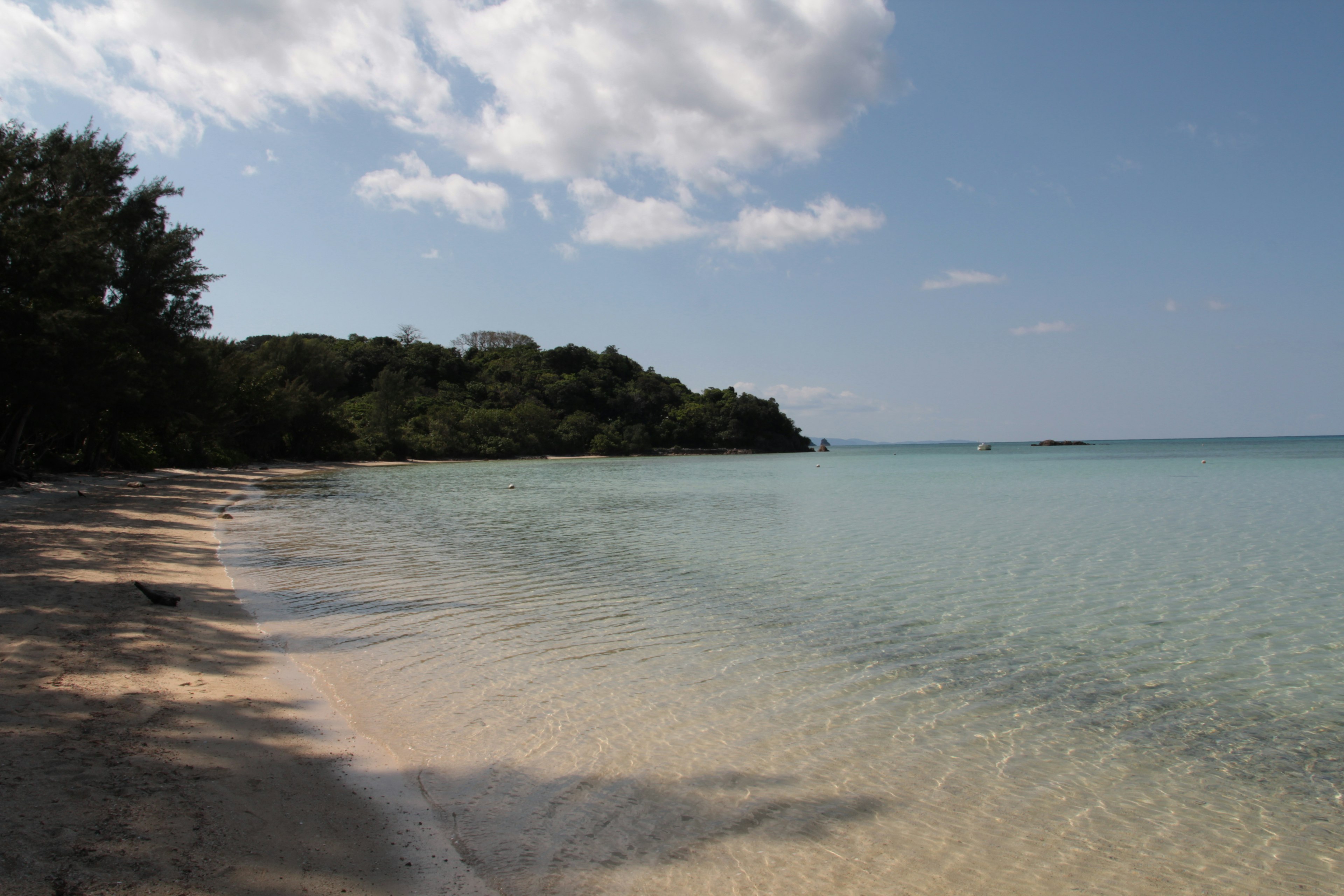 ทิวทัศน์ชายหาดที่เงียบสงบพร้อมน้ำที่สงบและทรายขาว