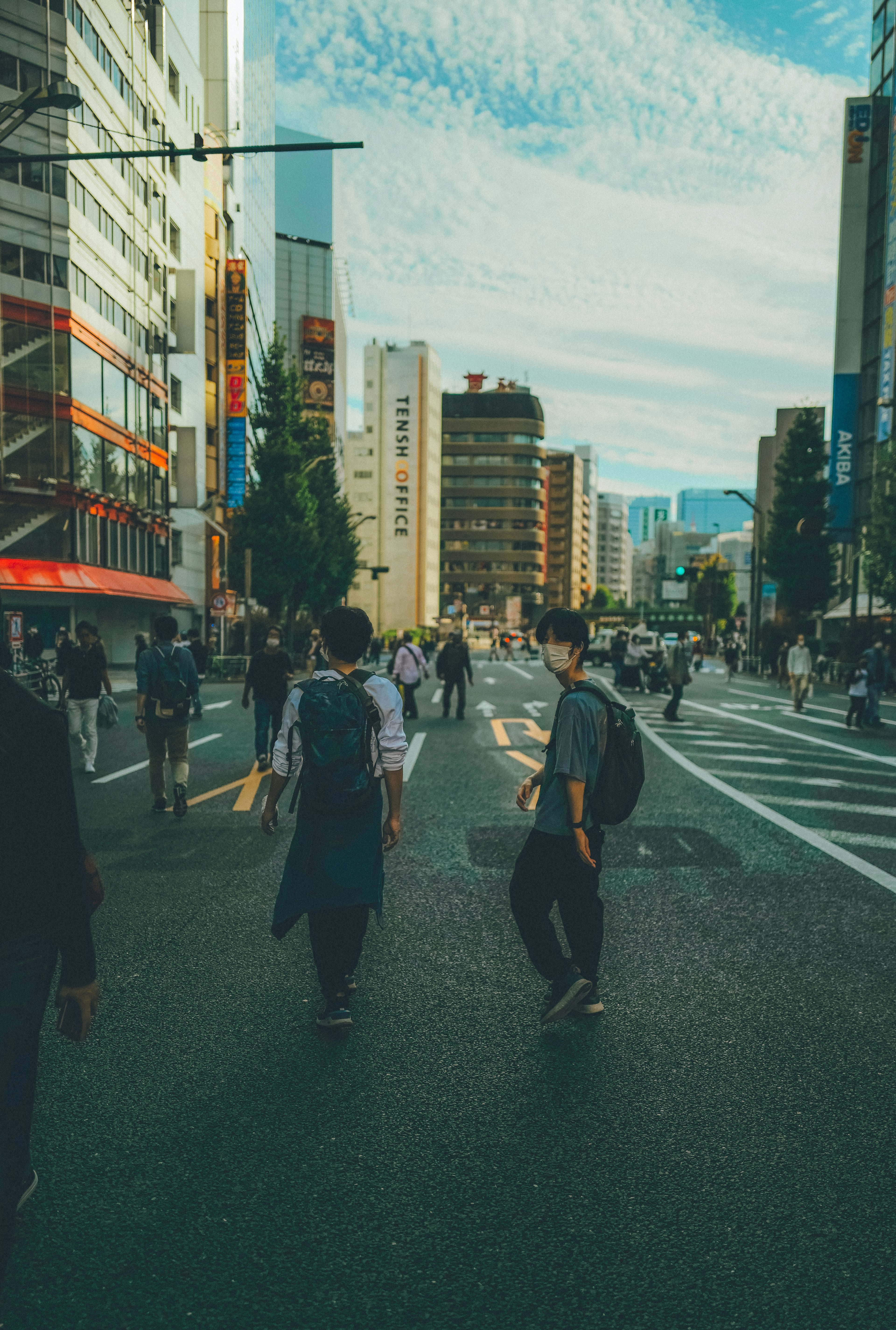 人々が都市の通りを歩いている風景ビルが並び青空が広がる